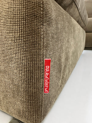Gebrauchtes braunes Flexform Groundpiece Designer Stoff Sofa vor einer Wand, stilvoll und modern eingerichtet.