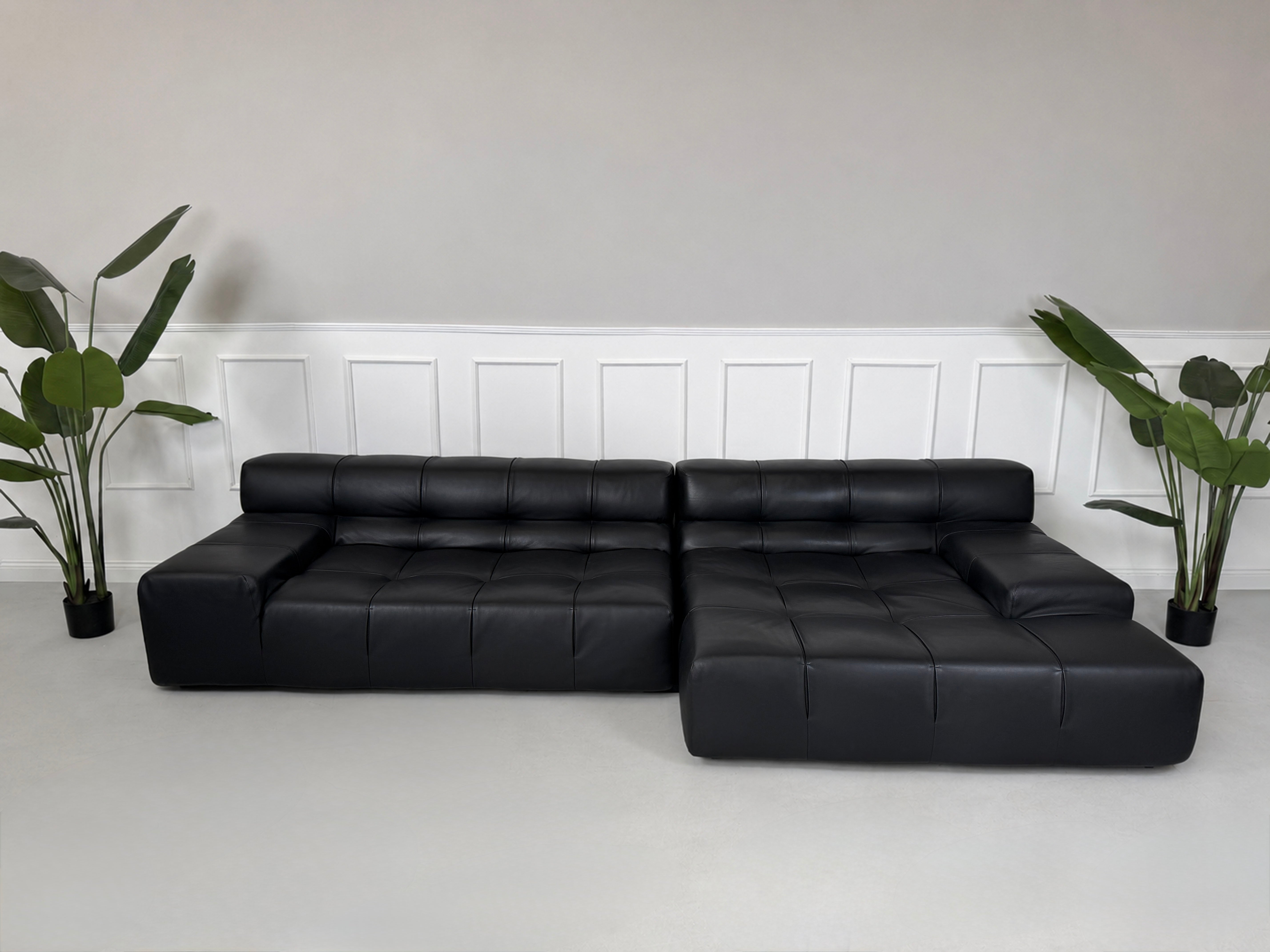 Gebrauchtes schwarzes B&B Italia Tufty Time Designer Leder Sofa vor einer Wand, stilvoll und modern eingerichtet.