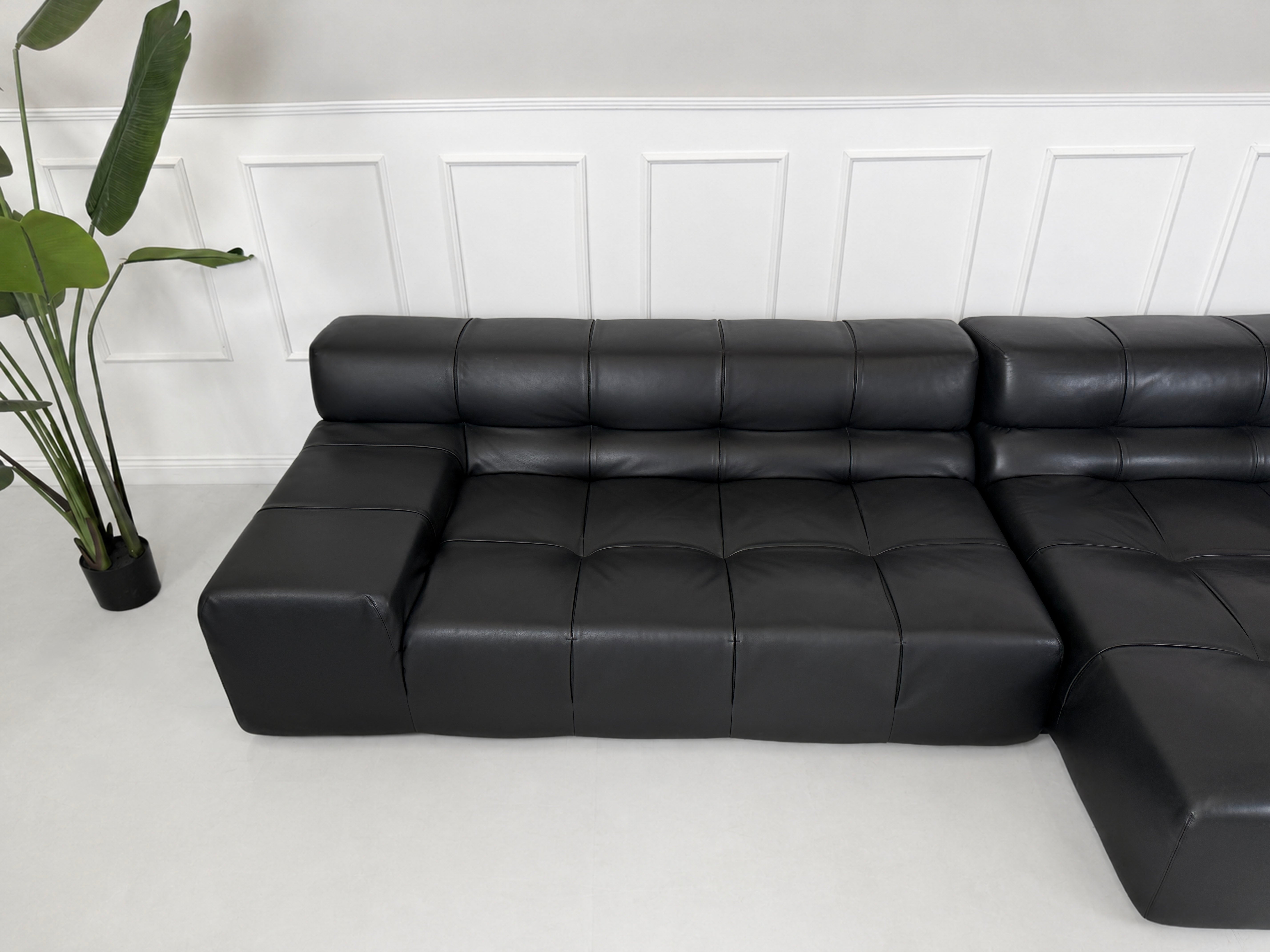 Gebrauchtes schwarzes B&B Italia Tufty Time Designer Leder Sofa vor einer Wand, stilvoll und modern eingerichtet.