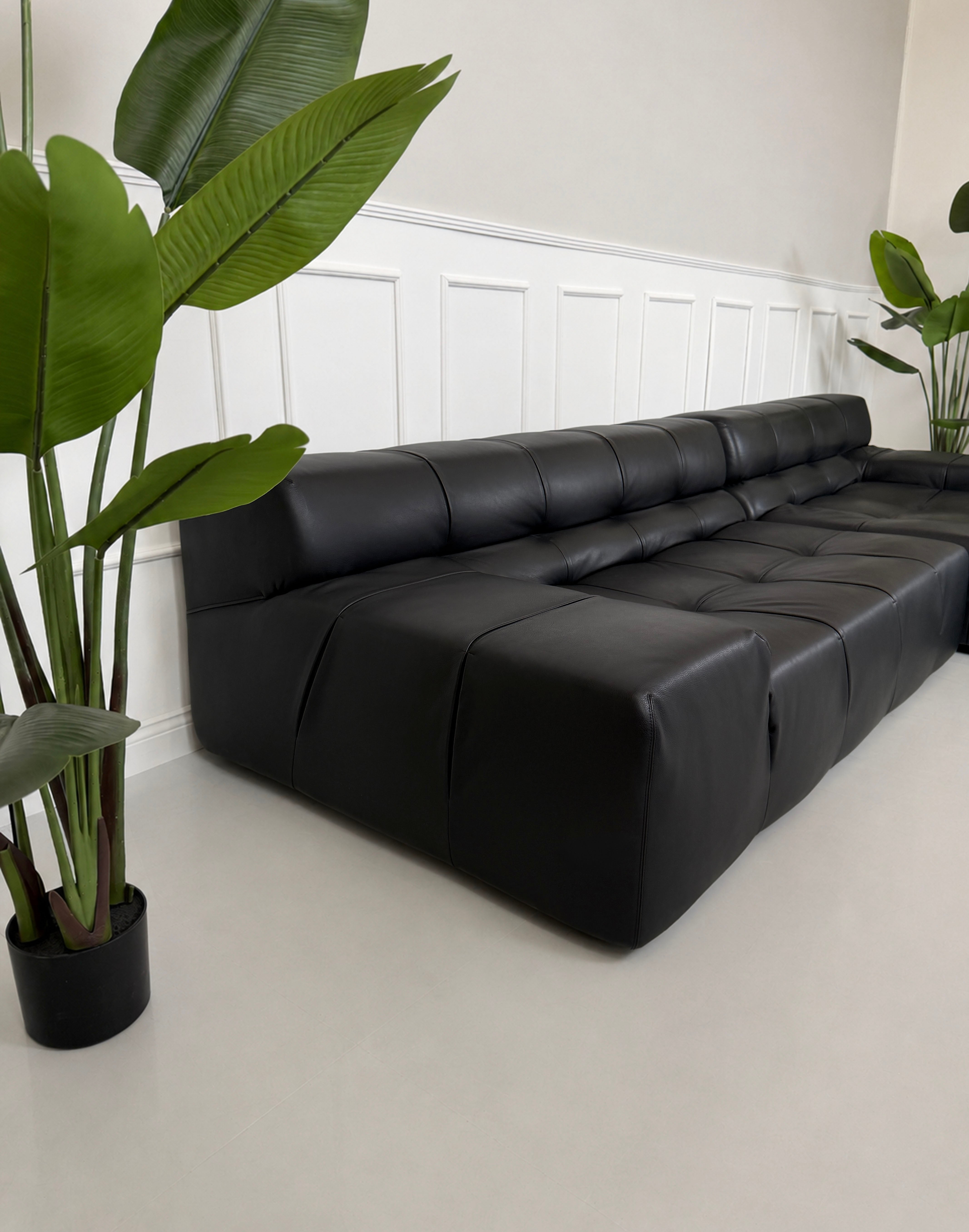 Gebrauchtes schwarzes B&B Italia Tufty Time Designer Leder Sofa vor einer Wand, stilvoll und modern eingerichtet.