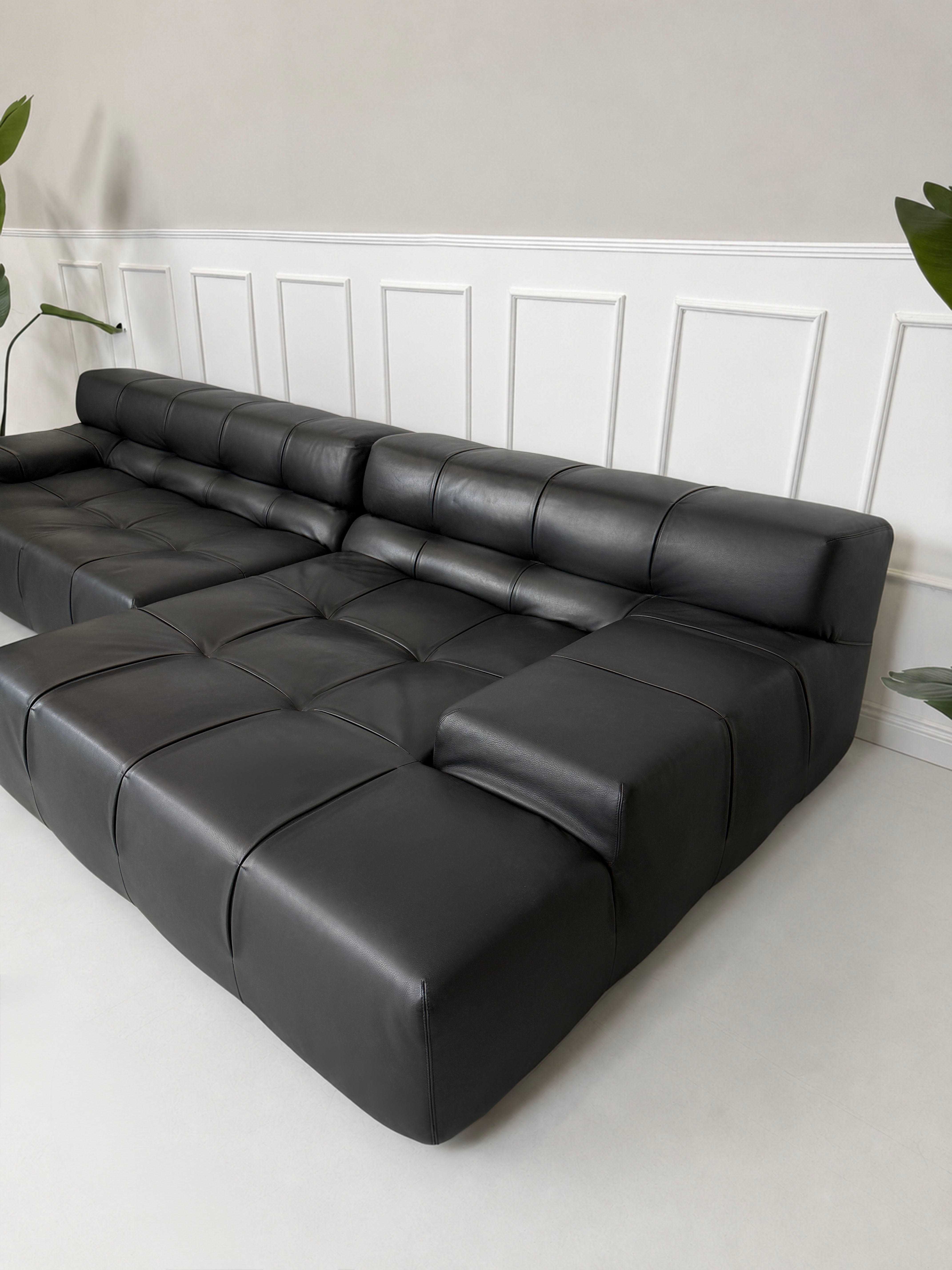 Gebrauchtes schwarzes B&B Italia Tufty Time Designer Leder Sofa vor einer Wand, stilvoll und modern eingerichtet.