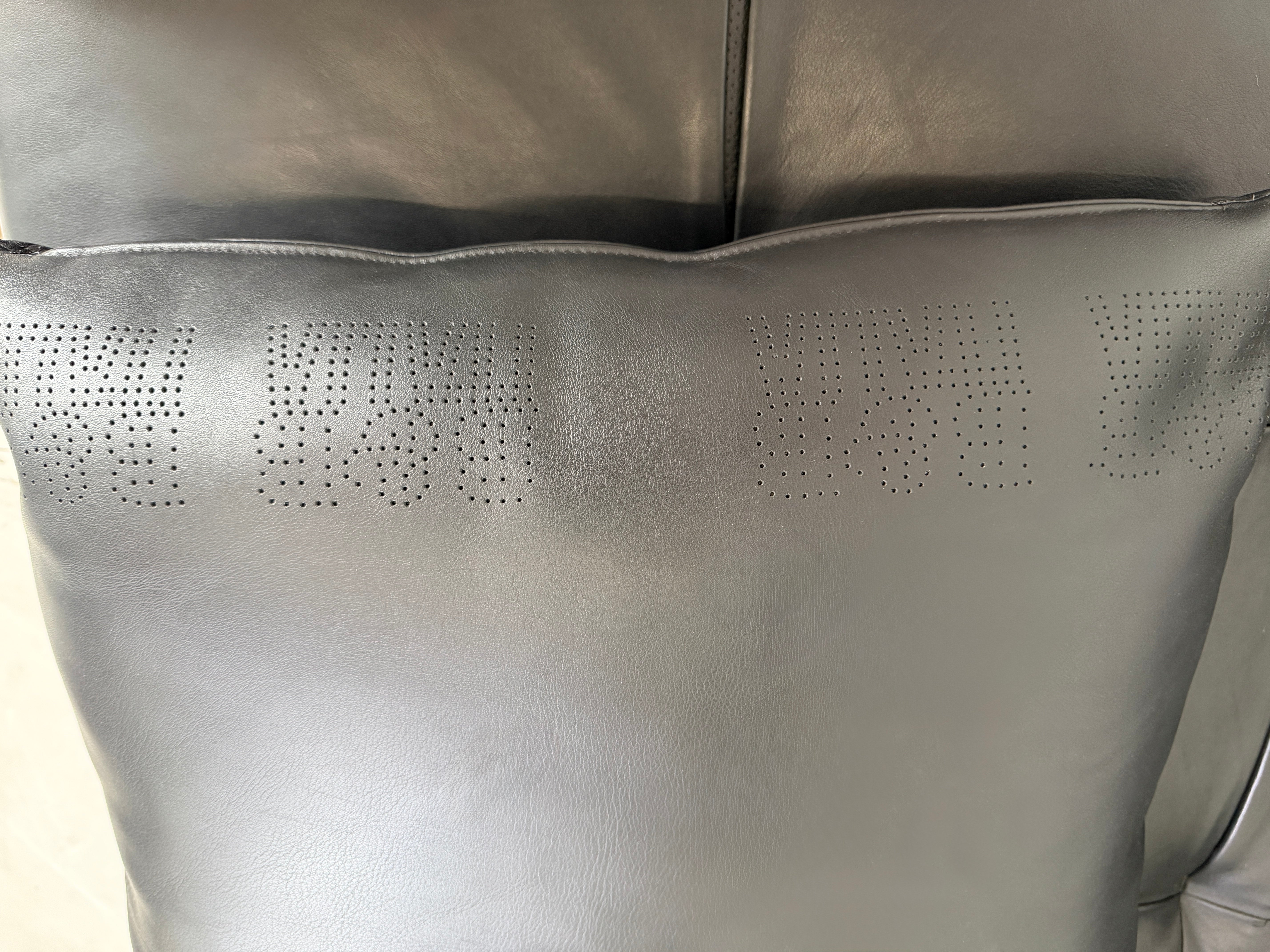 Gebrauchtes schwarzes B&B Italia Tufty Time Designer Leder Sofa vor einer Wand, stilvoll und modern eingerichtet.
