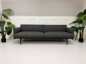 Gebrauchtes graues Muuto Outline Designer Stoff Sofa vor einer Wand, stilvoll und modern eingerichtet.