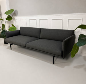 Gebrauchtes graues Muuto Outline Designer Stoff Sofa vor einer Wand, stilvoll und modern eingerichtet.