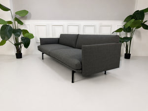 Gebrauchtes graues Muuto Outline Designer Stoff Sofa vor einer Wand, stilvoll und modern eingerichtet.