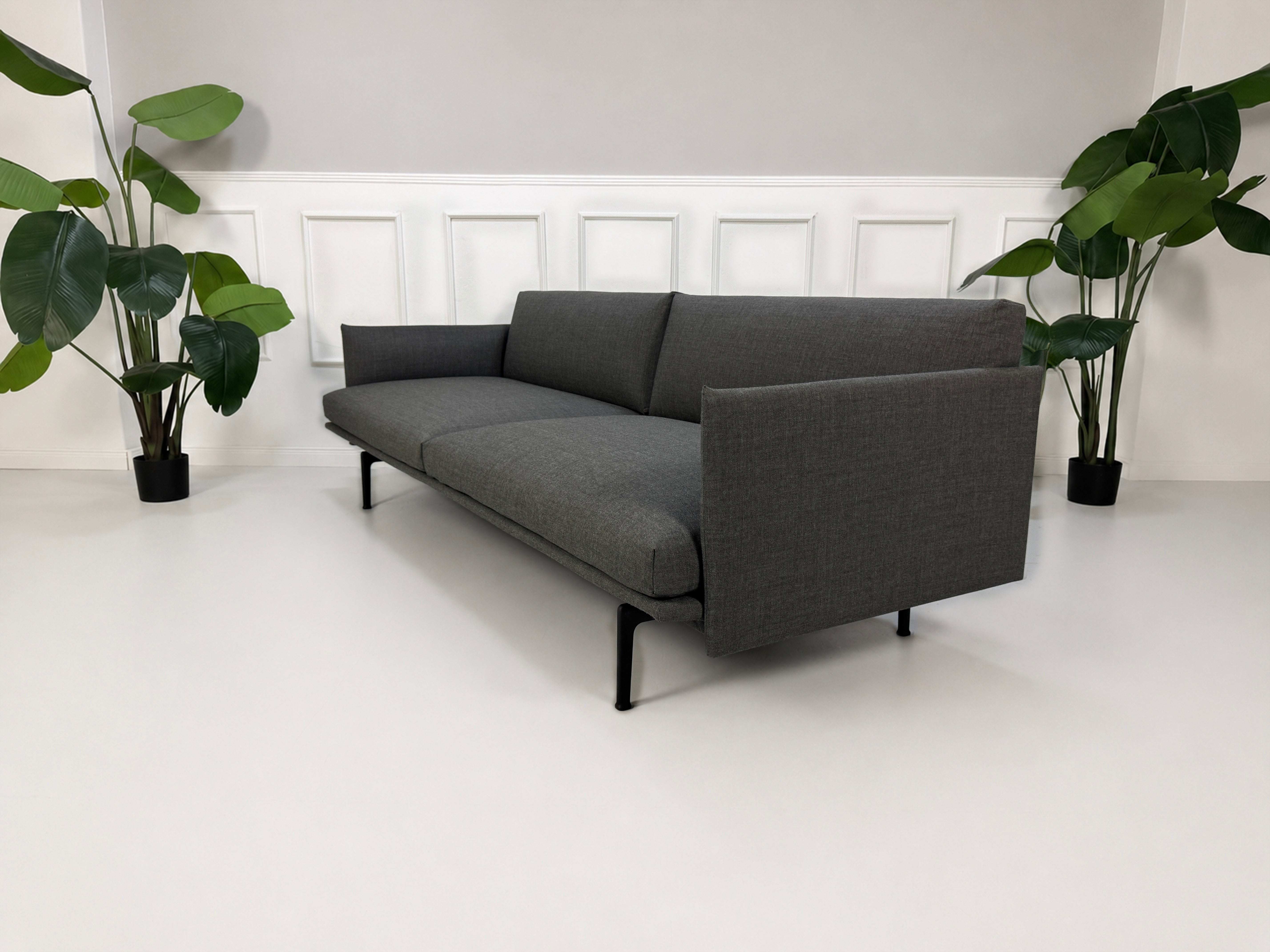 Gebrauchtes graues Muuto Outline Designer Stoff Sofa vor einer Wand, stilvoll und modern eingerichtet.