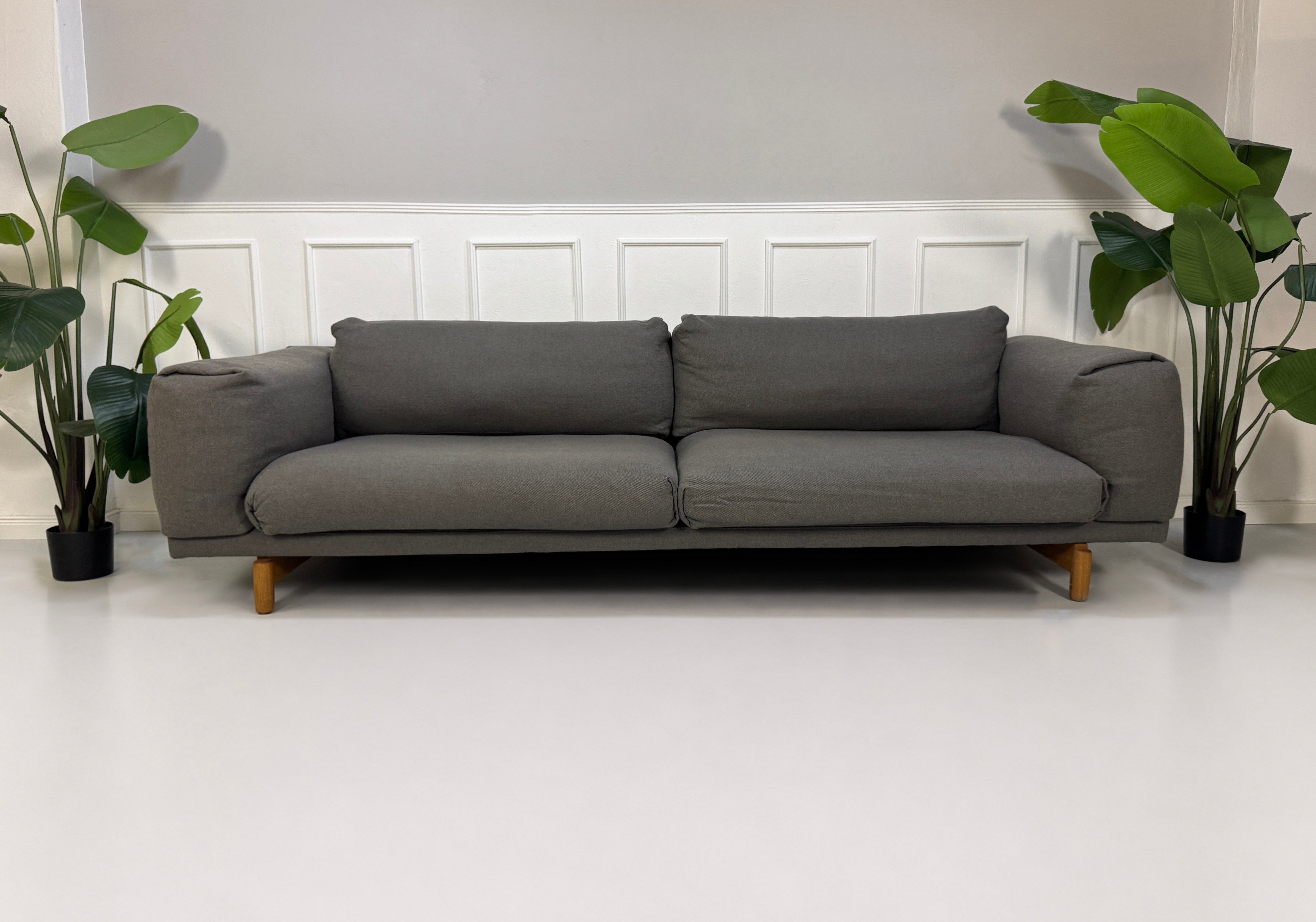 Gebrauchtes graues Muuto Rest Designer Stoff Sofa mit Hocker vor einer Wand, stilvoll und modern eingerichtet.