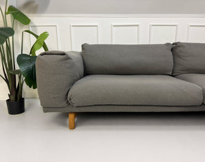 Gebrauchtes graues Muuto Rest Designer Stoff Sofa mit Hocker vor einer Wand, stilvoll und modern eingerichtet.
