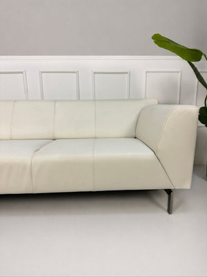 Gebrauchtes weißes Rolf Benz Linea 318 Designer Leder Sofa vor einer Wand, stilvoll und modern eingerichtet.