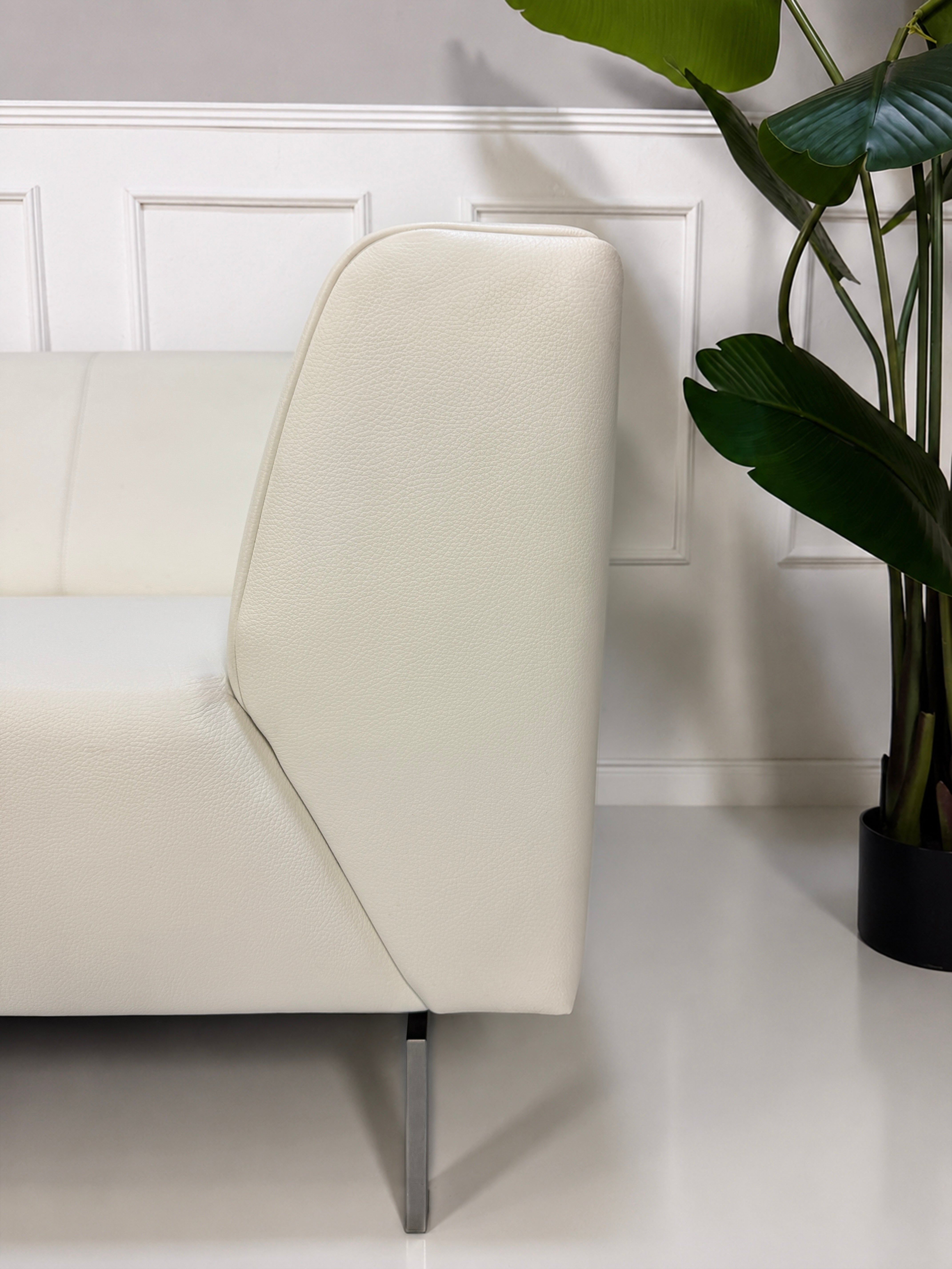 Gebrauchtes weißes Rolf Benz Linea 318 Designer Leder Sofa vor einer Wand, stilvoll und modern eingerichtet.