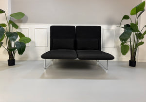 Gebrauchtes graues Brühl Roro Designer Stoff Sofa vor einer Wand, stilvoll und modern eingerichtet.