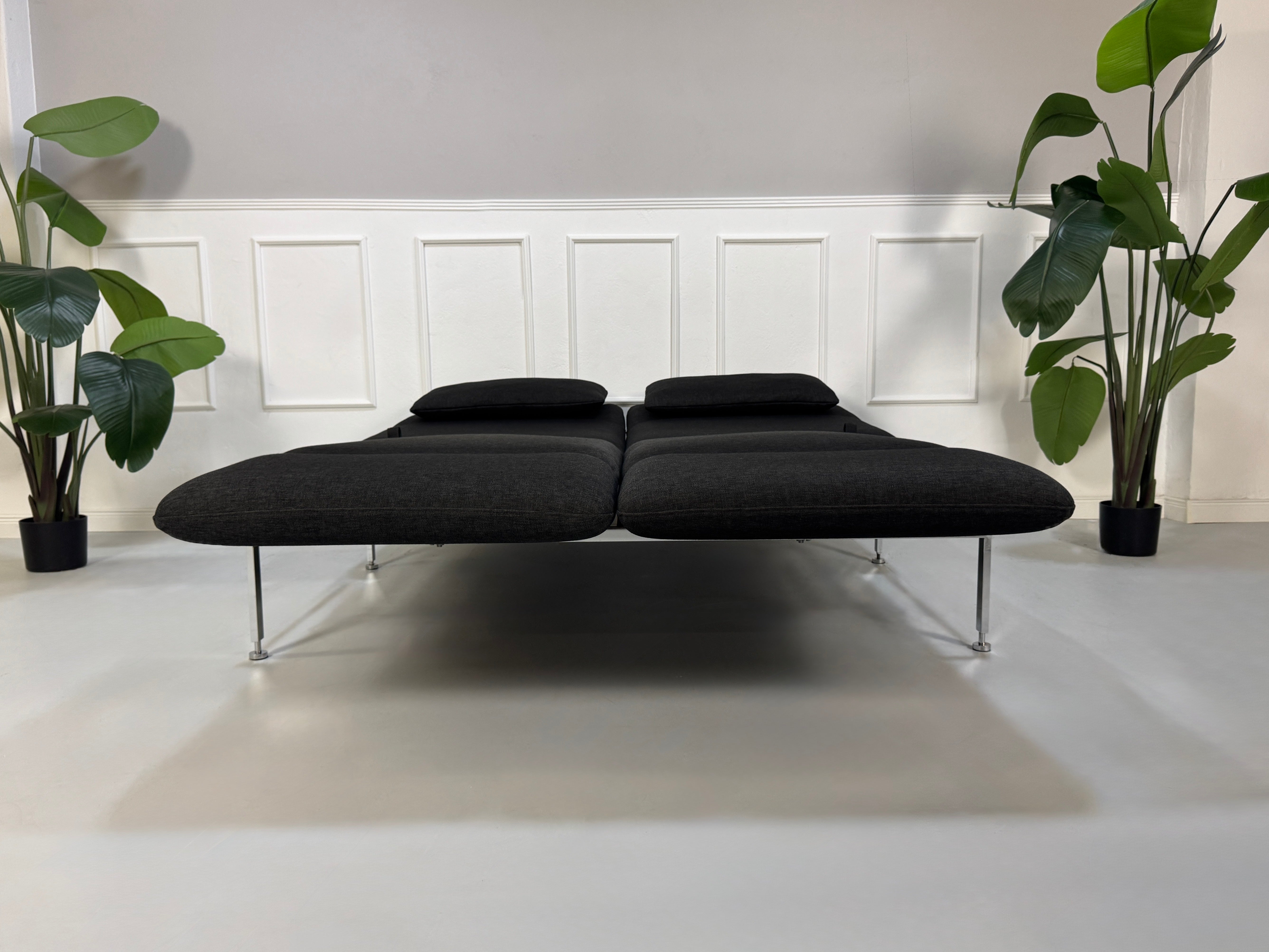 Gebrauchtes graues Brühl Roro Designer Stoff Sofa vor einer Wand, stilvoll und modern eingerichtet.