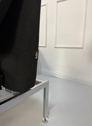 Gebrauchtes graues Brühl Roro Designer Stoff Sofa vor einer Wand, stilvoll und modern eingerichtet.