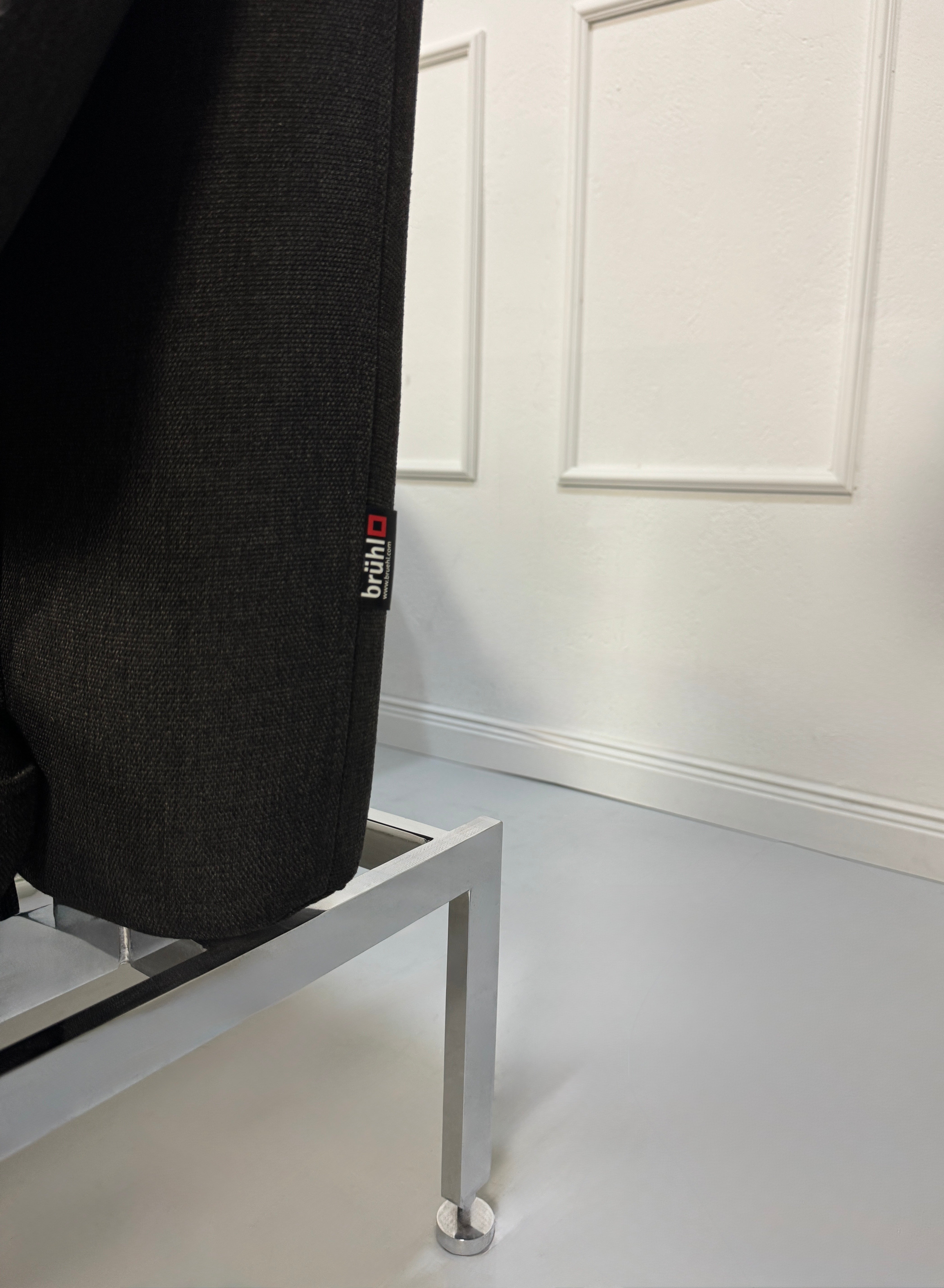 Gebrauchtes graues Brühl Roro Designer Stoff Sofa vor einer Wand, stilvoll und modern eingerichtet.