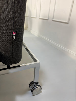 Gebrauchtes graues Brühl Roro Designer Stoff Sofa vor einer Wand, stilvoll und modern eingerichtet.
