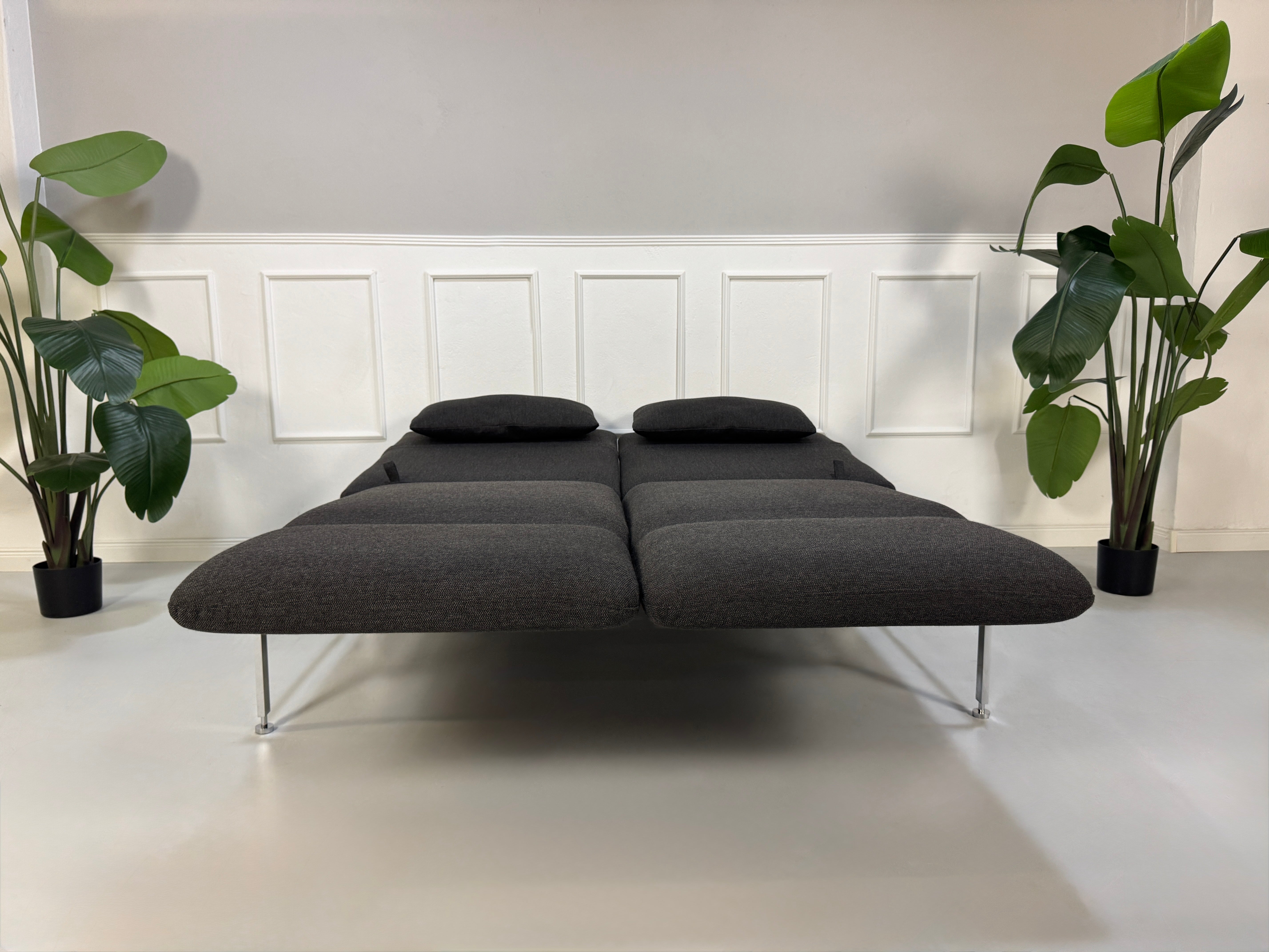 Gebrauchtes graues Brühl Roro Designer Stoff Sofa vor einer Wand, stilvoll und modern eingerichtet.
