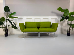 Gebrauchtes grünes Brühl Roro Designer Stoff Sofa vor einer Wand, stilvoll und modern eingerichtet.