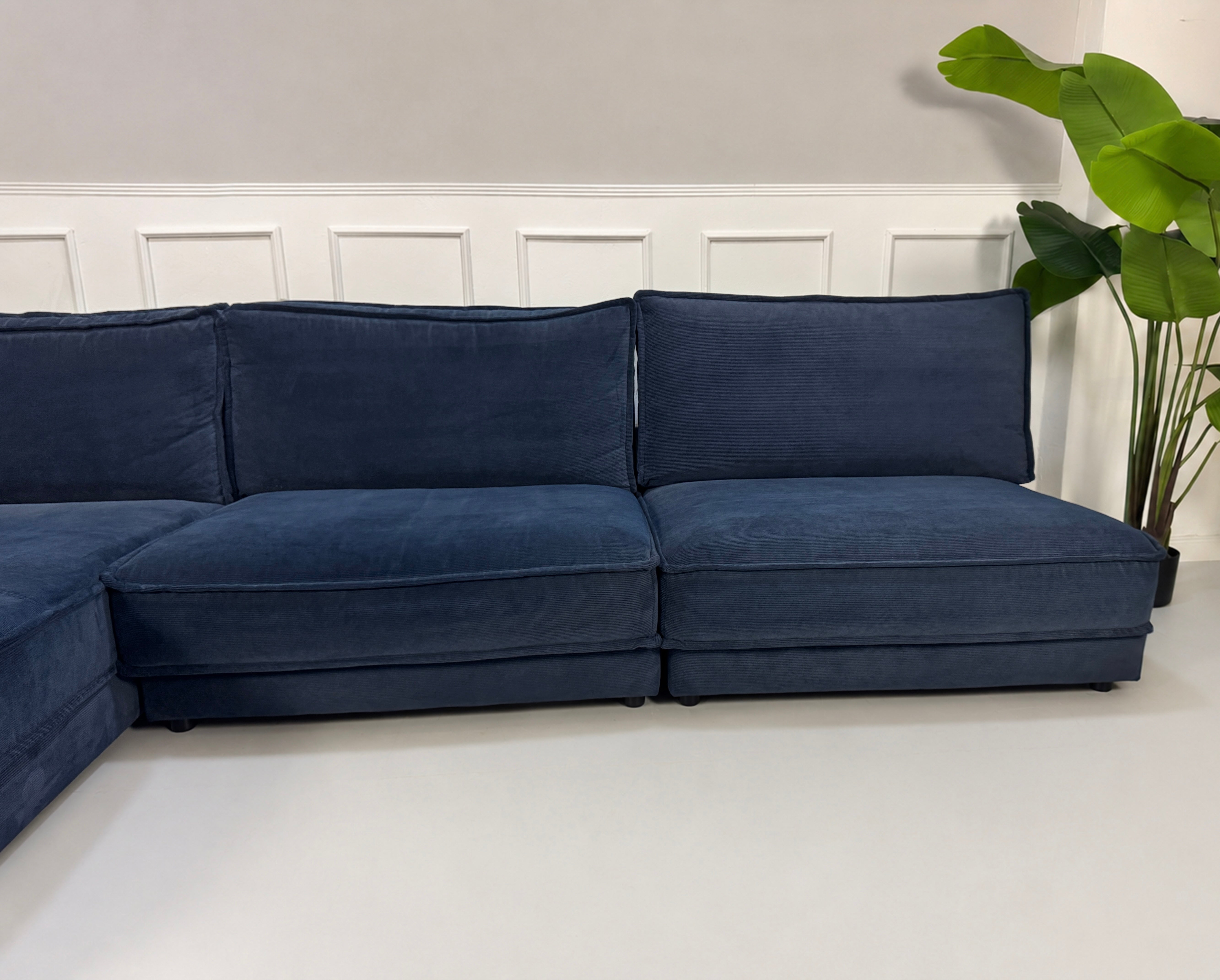 Gebrauchtes blaues Bolia Noora Designer Stoff Sofa vor einer Wand, stilvoll und modern eingerichtet.