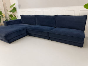 Gebrauchtes blaues Bolia Noora Designer Stoff Sofa vor einer Wand, stilvoll und modern eingerichtet.