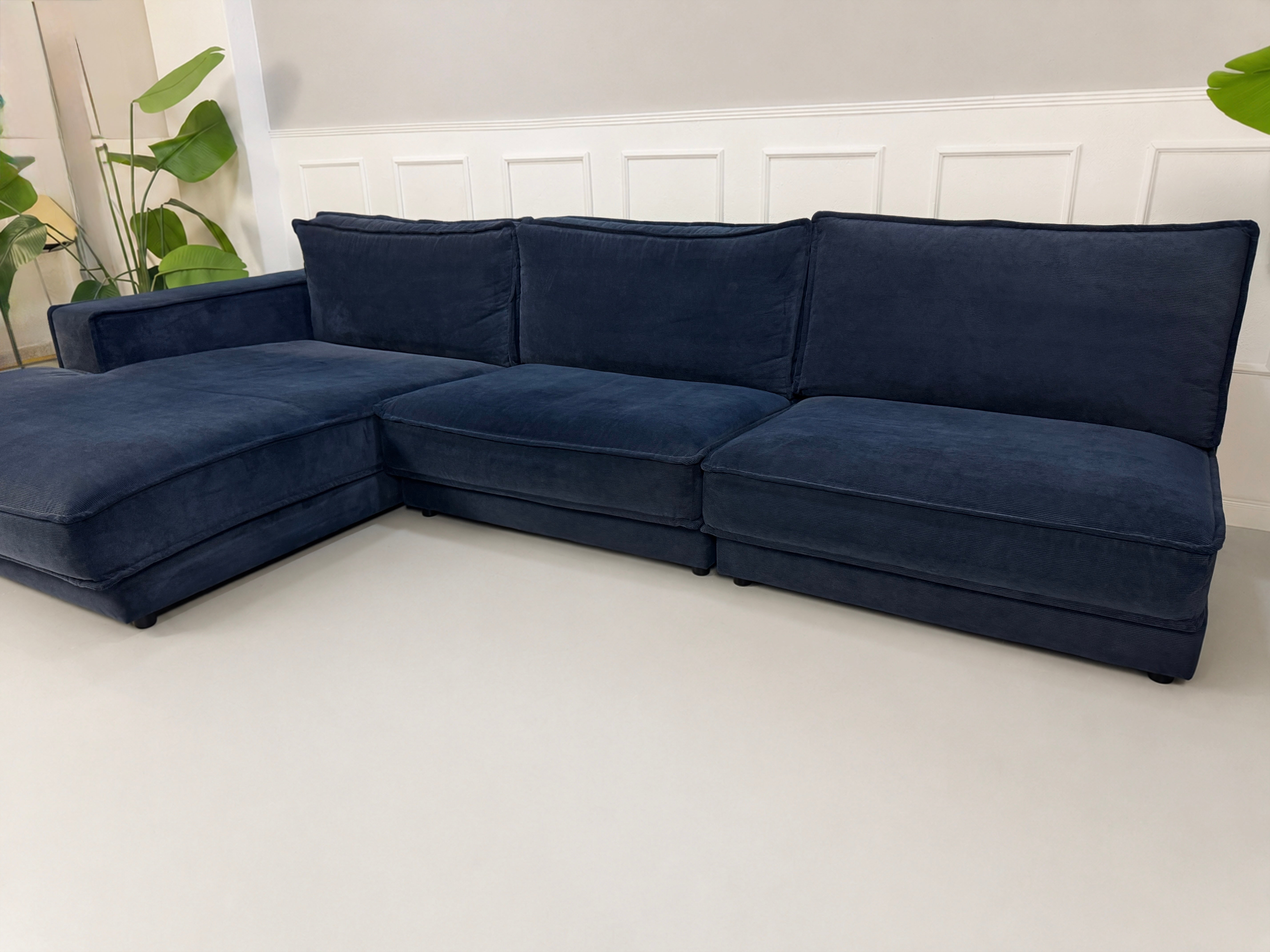 Gebrauchtes blaues Bolia Noora Designer Stoff Sofa vor einer Wand, stilvoll und modern eingerichtet.