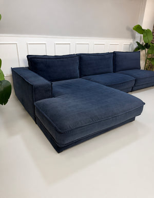 Gebrauchtes blaues Bolia Noora Designer Stoff Sofa vor einer Wand, stilvoll und modern eingerichtet.