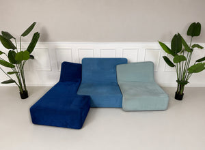 Gebrauchtes blaues Ligne Roset Confluences Designer Stoff Sofa vor einer Wand, stilvoll und modern eingerichtet.