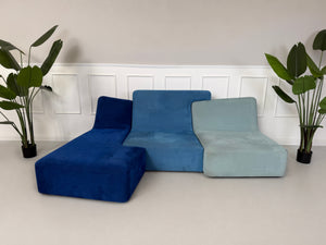 Gebrauchtes blaues Ligne Roset Confluences Designer Stoff Sofa vor einer Wand, stilvoll und modern eingerichtet.