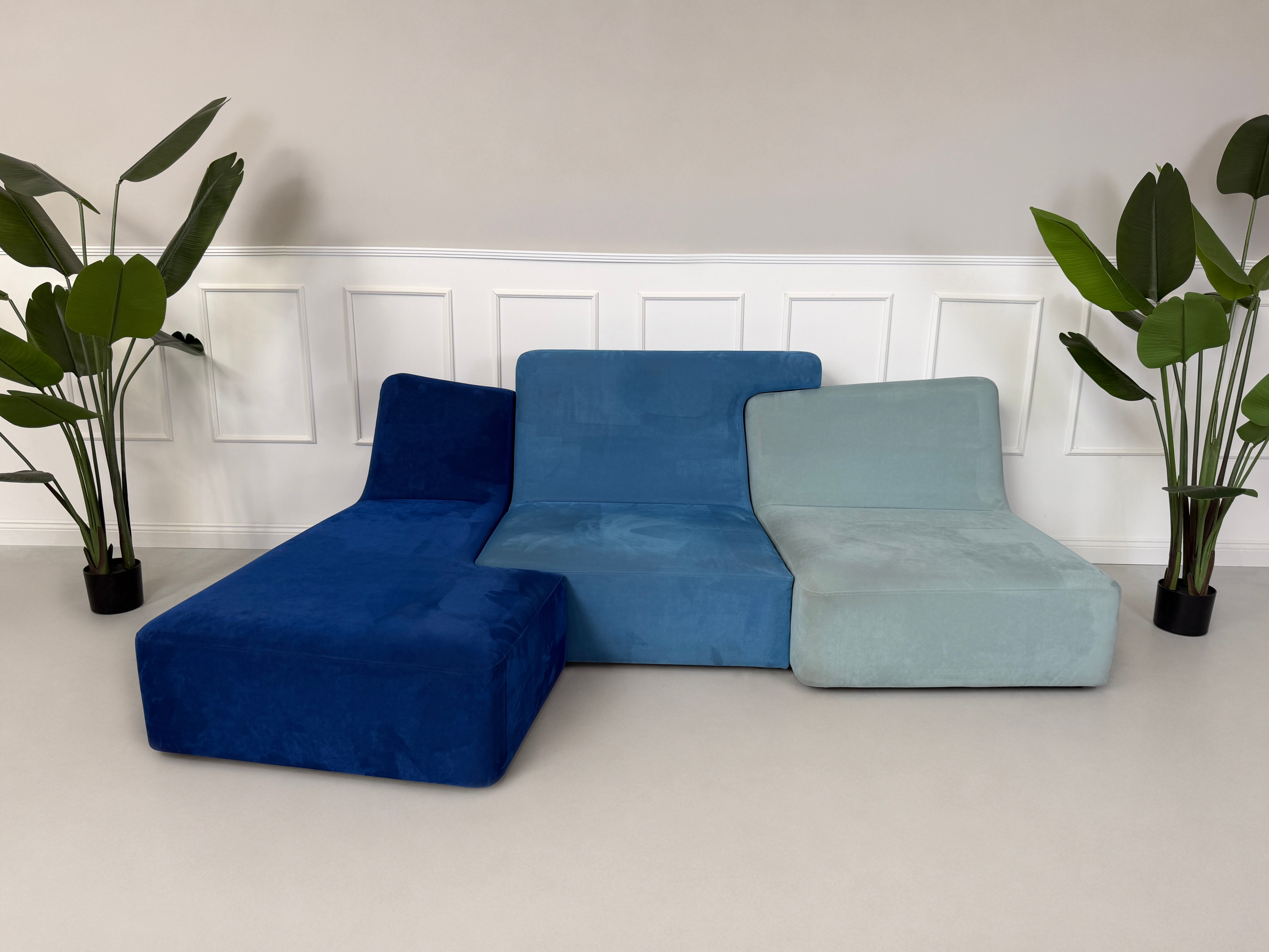Gebrauchtes blaues Ligne Roset Confluences Designer Stoff Sofa vor einer Wand, stilvoll und modern eingerichtet.