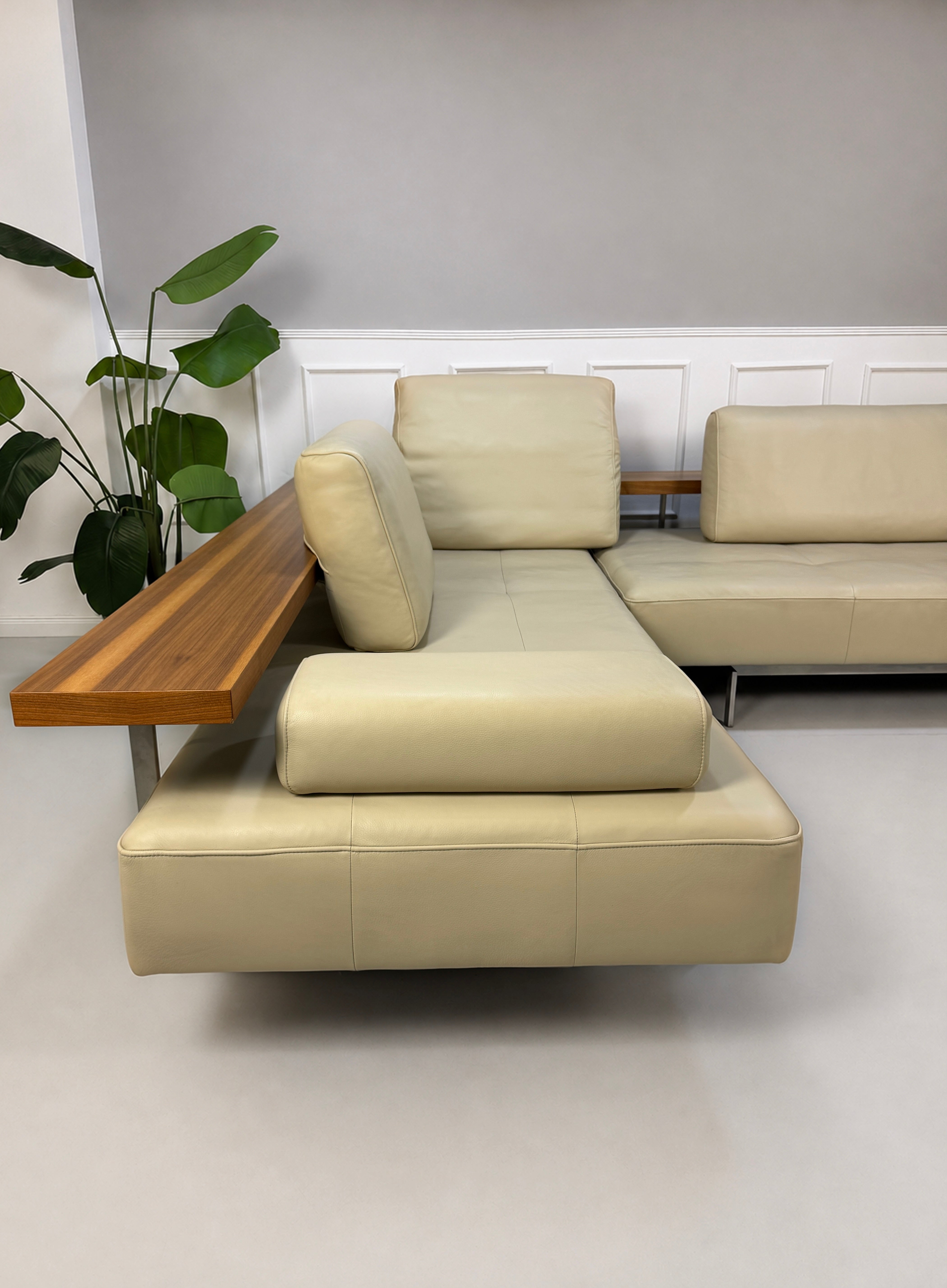 Gebrauchtes beiges Rolf Benz Dono Designer Leder Sofa vor einer Wand, stilvoll und modern eingerichtet.