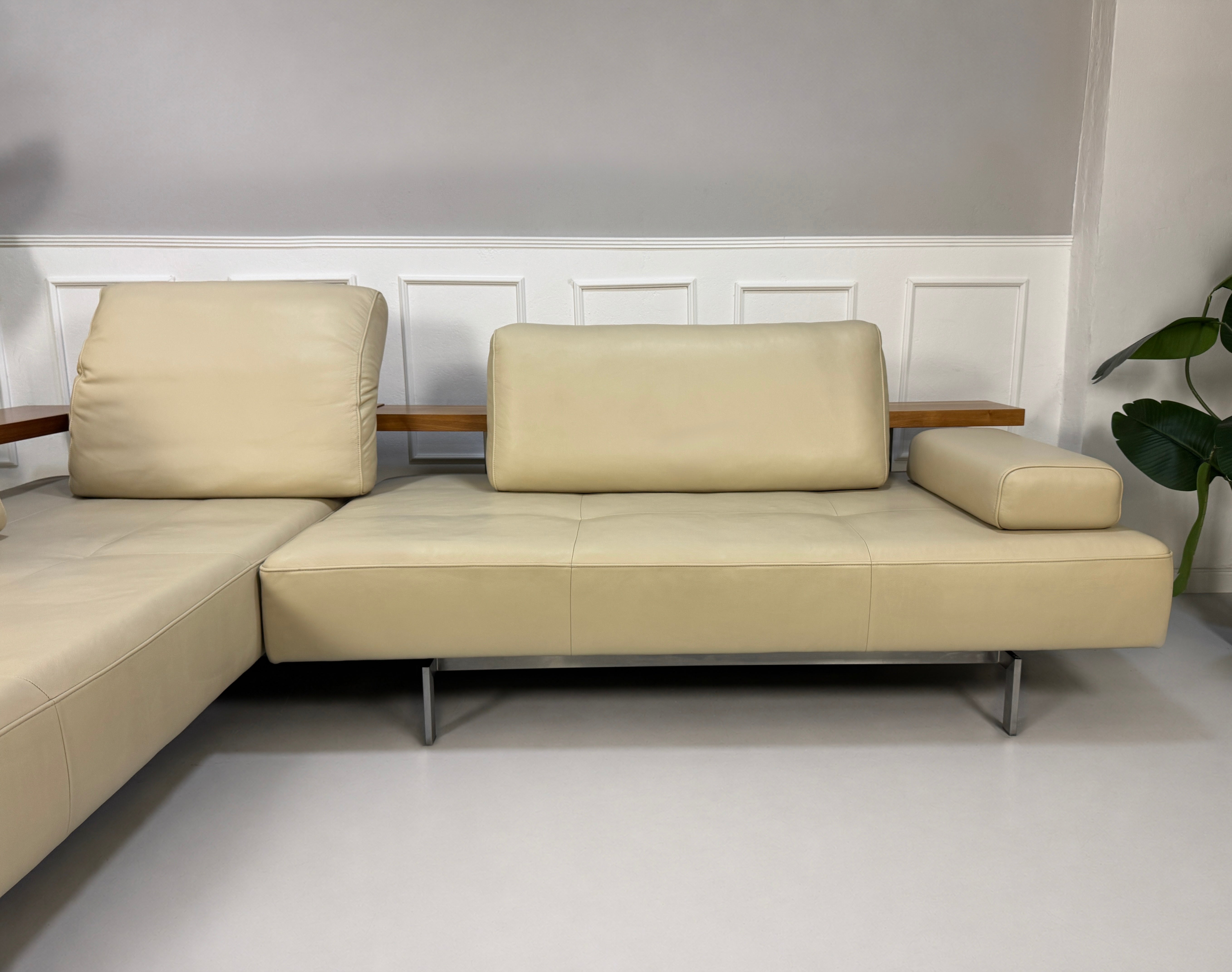 Gebrauchtes beiges Rolf Benz Dono Designer Leder Sofa vor einer Wand, stilvoll und modern eingerichtet.