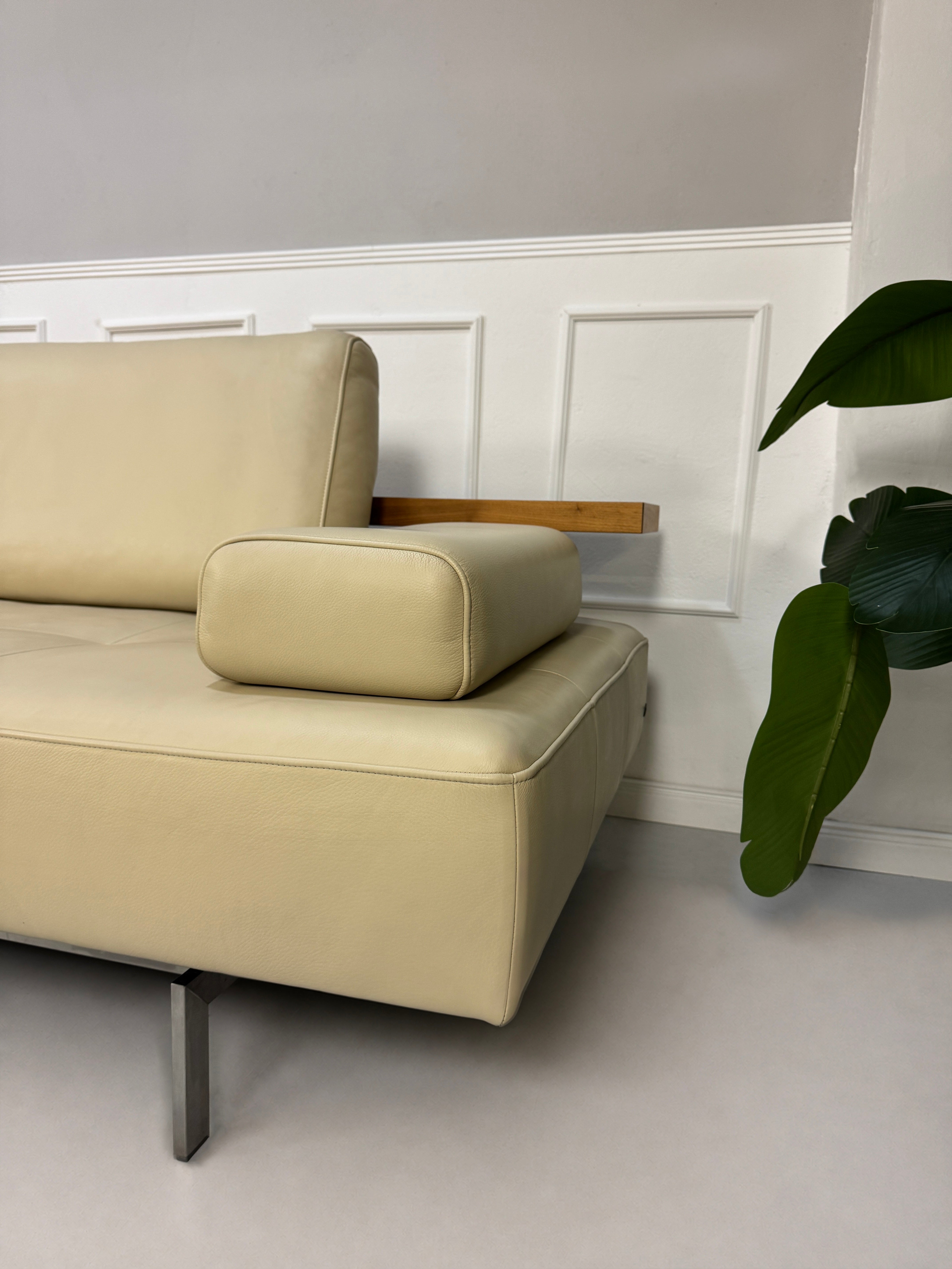 Gebrauchtes beiges Rolf Benz Dono Designer Leder Sofa vor einer Wand, stilvoll und modern eingerichtet.