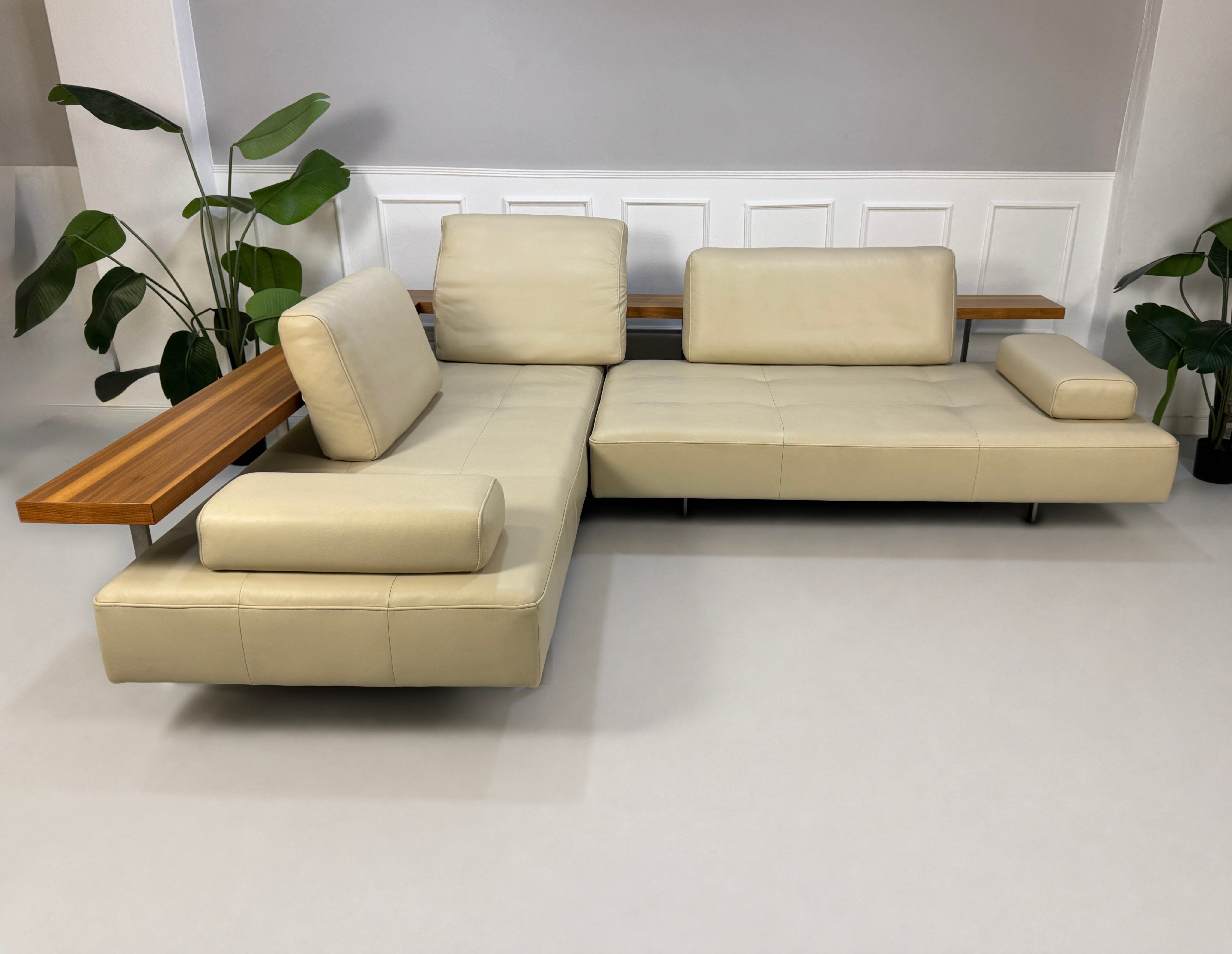 Gebrauchtes beiges Rolf Benz Dono Designer Leder Sofa vor einer Wand, stilvoll und modern eingerichtet.
