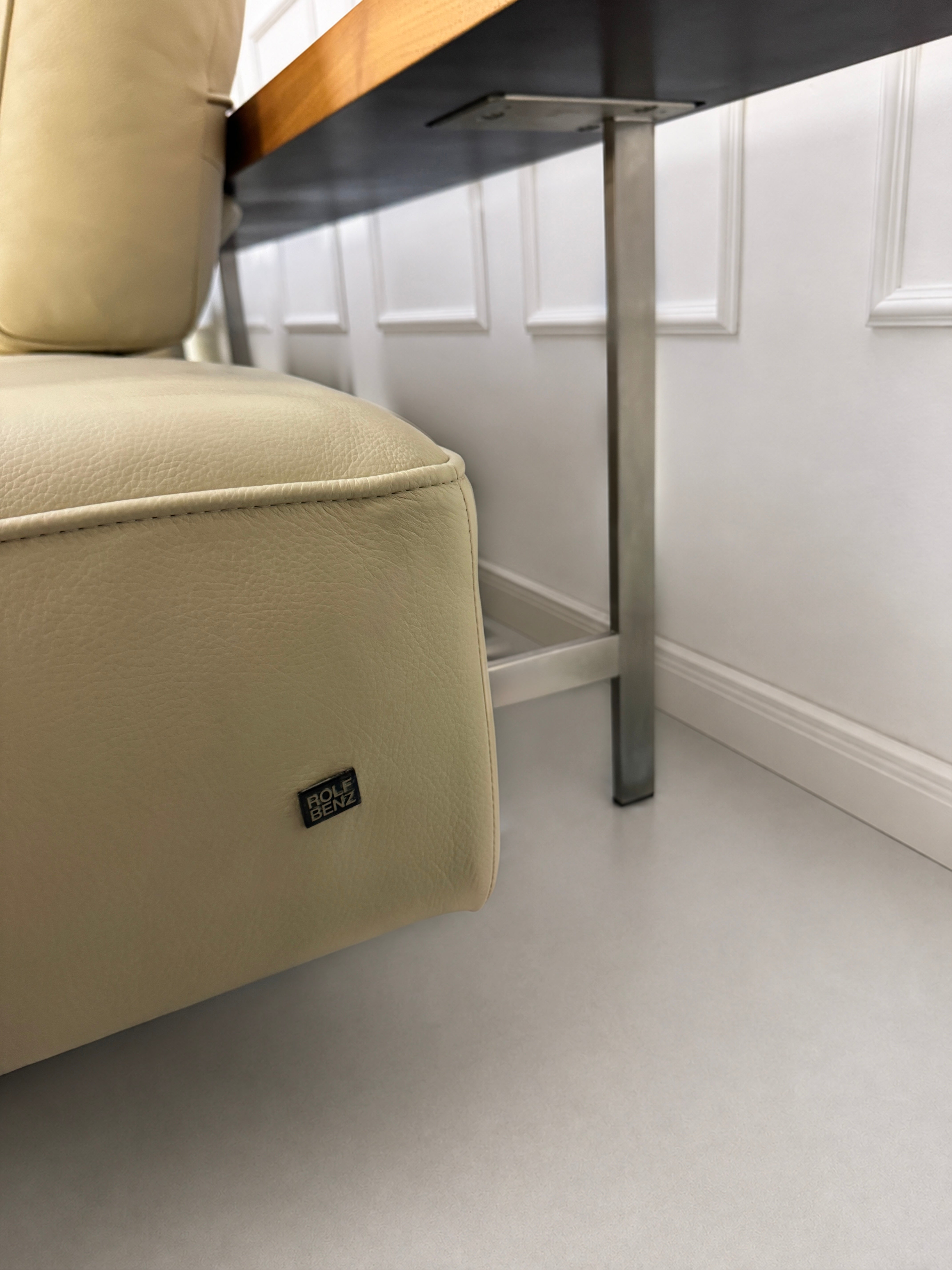 Gebrauchtes beiges Rolf Benz Dono Designer Leder Sofa vor einer Wand, stilvoll und modern eingerichtet.