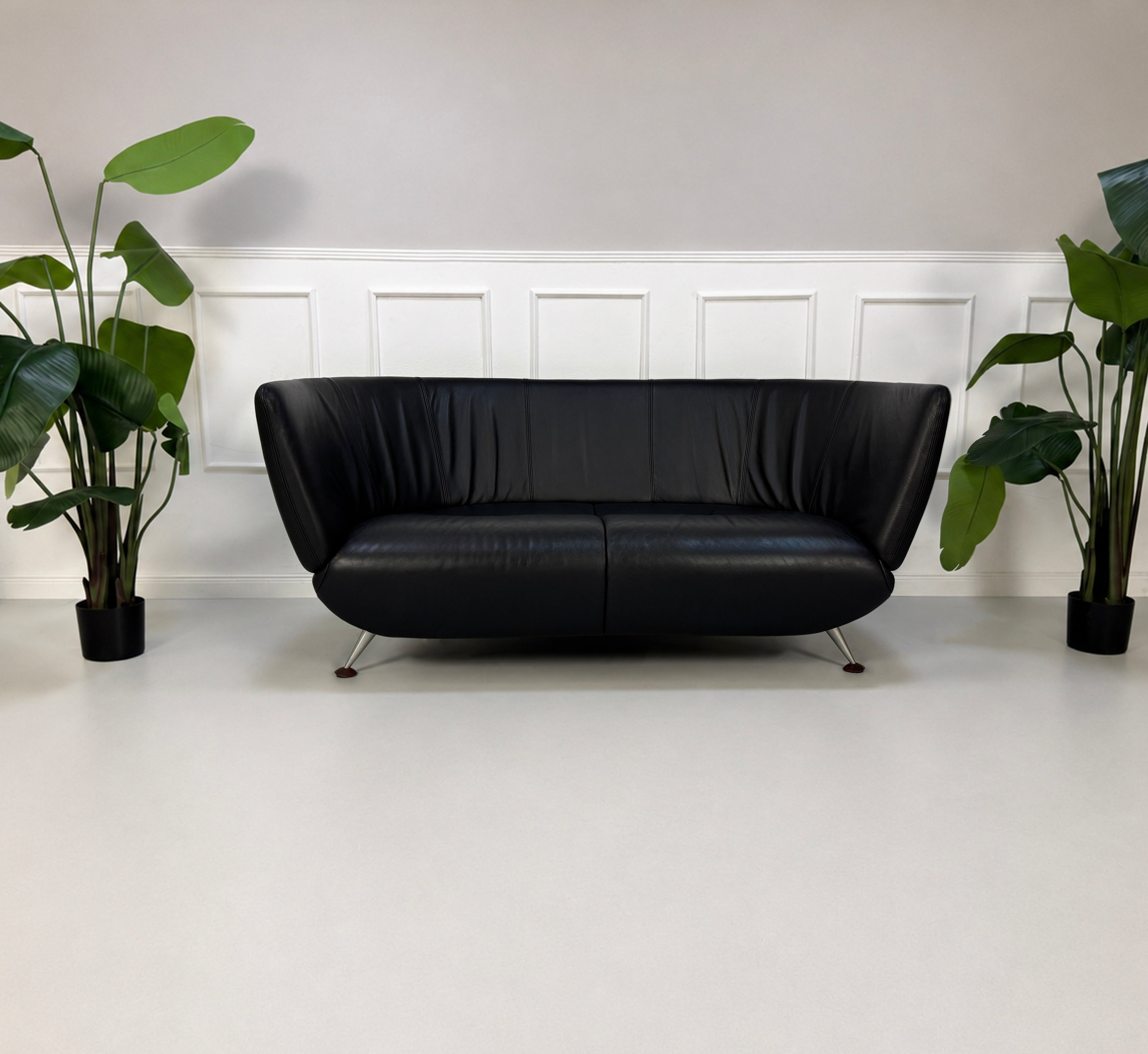 Gebrauchtes schwarzes De Sede DS 102 Designer Leder Sofa vor einer Wand, stilvoll und modern eingerichtet.