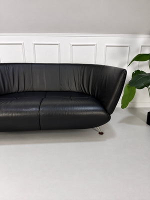 Gebrauchtes schwarzes De Sede DS 102 Designer Leder Sofa vor einer Wand, stilvoll und modern eingerichtet.