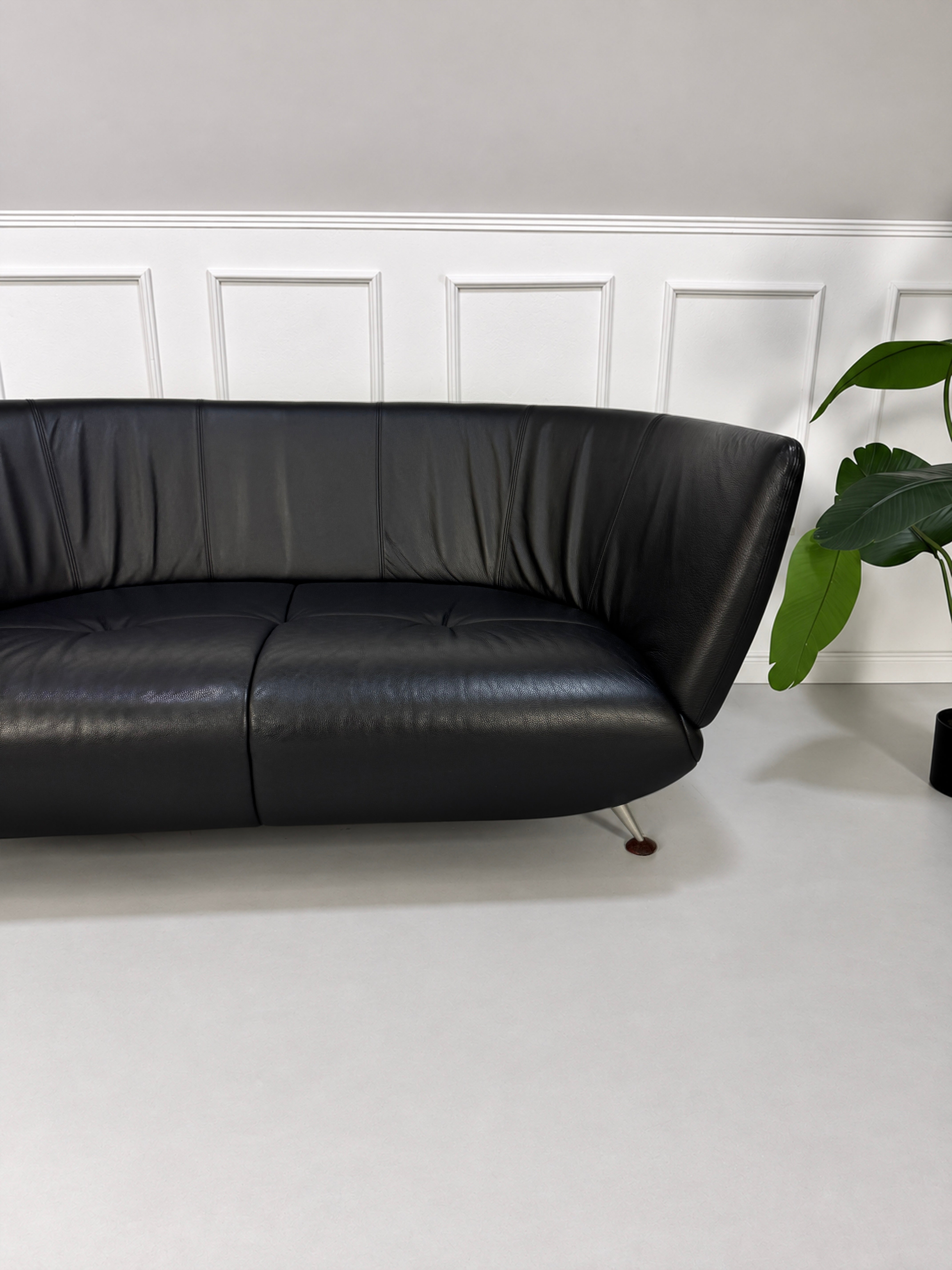 Gebrauchtes schwarzes De Sede DS 102 Designer Leder Sofa vor einer Wand, stilvoll und modern eingerichtet.