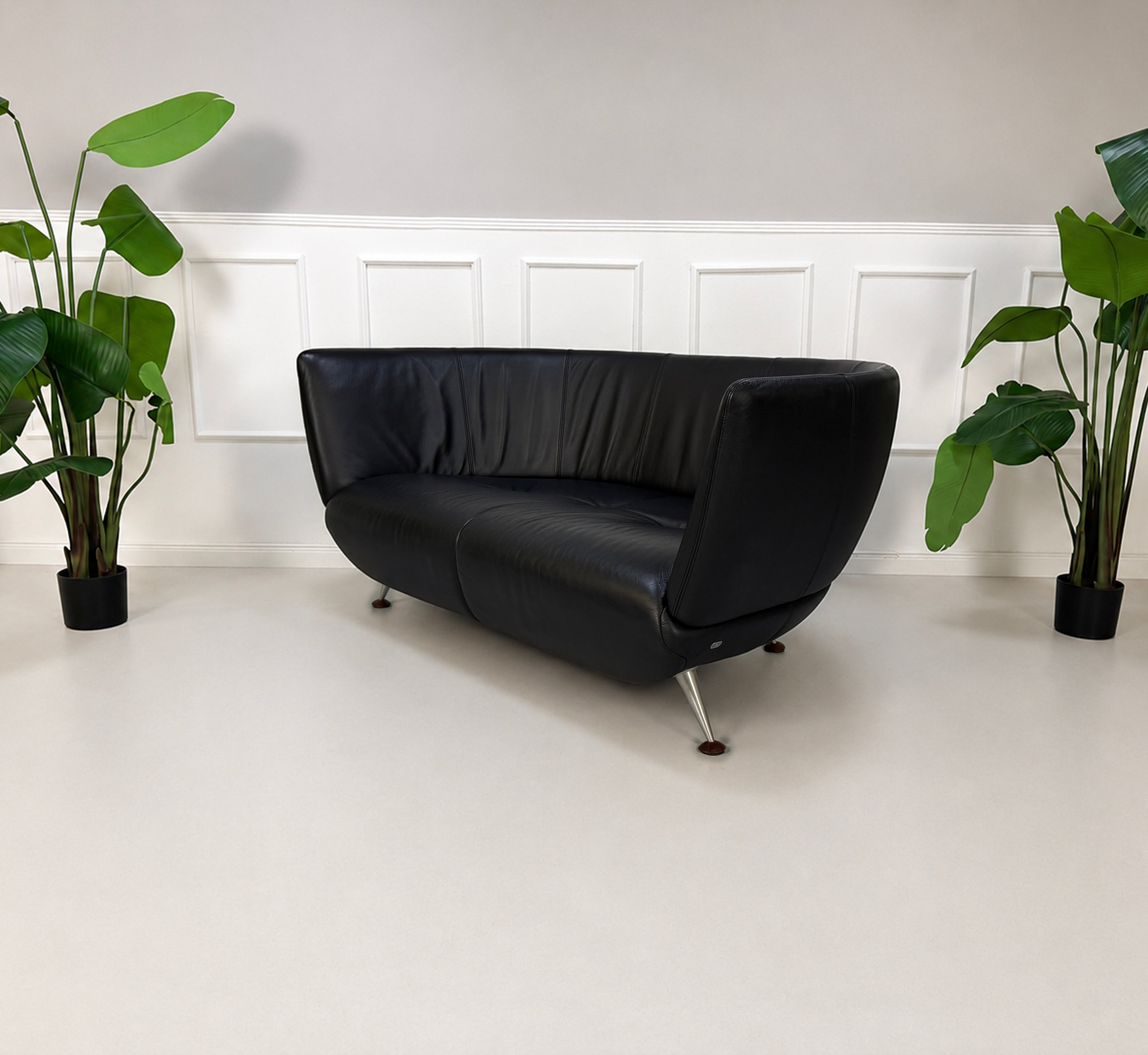 Gebrauchtes schwarzes De Sede DS 102 Designer Leder Sofa vor einer Wand, stilvoll und modern eingerichtet.