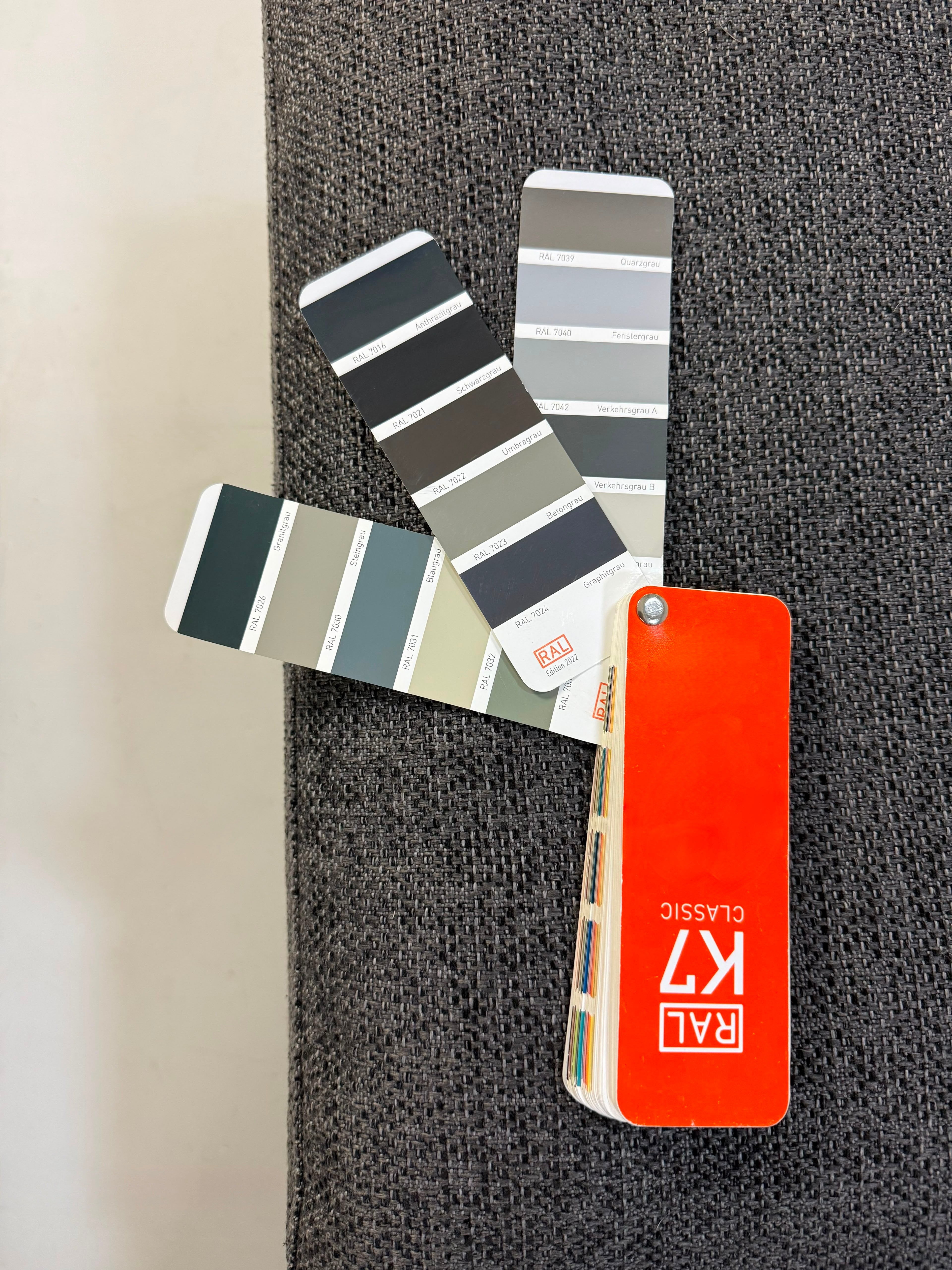 Gebrauchtes graues Brühl Roro Soft Designer Stoff Sofa vor einer Wand, stilvoll und modern eingerichtet.