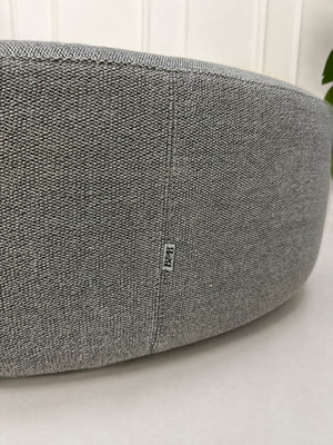 Gebrauchter grauer B&B Italia Charles Designer Stoff Hocker vor einer Wand, stilvoll und modern eingerichtet.
