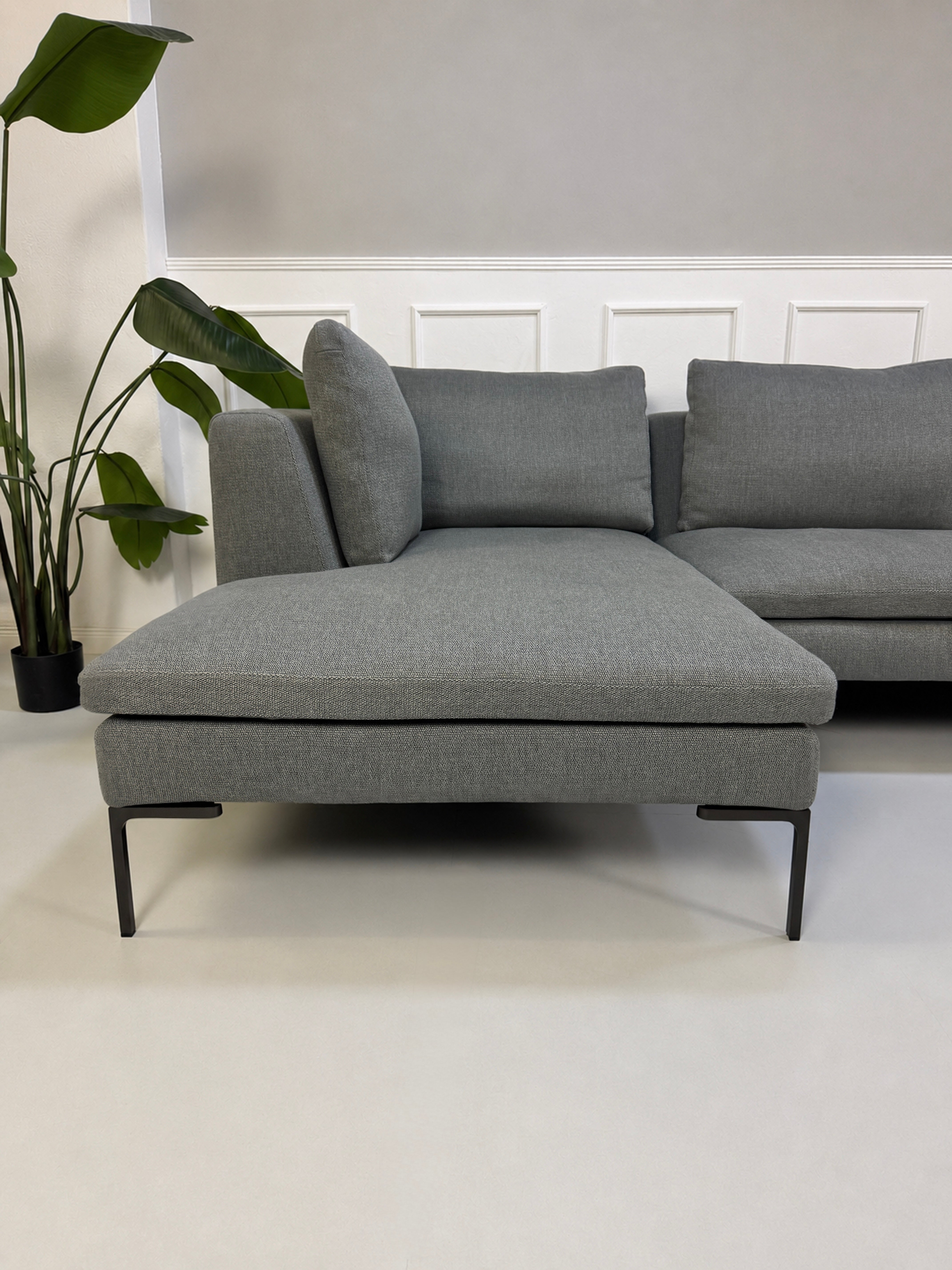 Gebrauchtes graues B&B Italia Charles Designer Stoff Sofa vor einer Wand, stilvoll und modern eingerichtet.