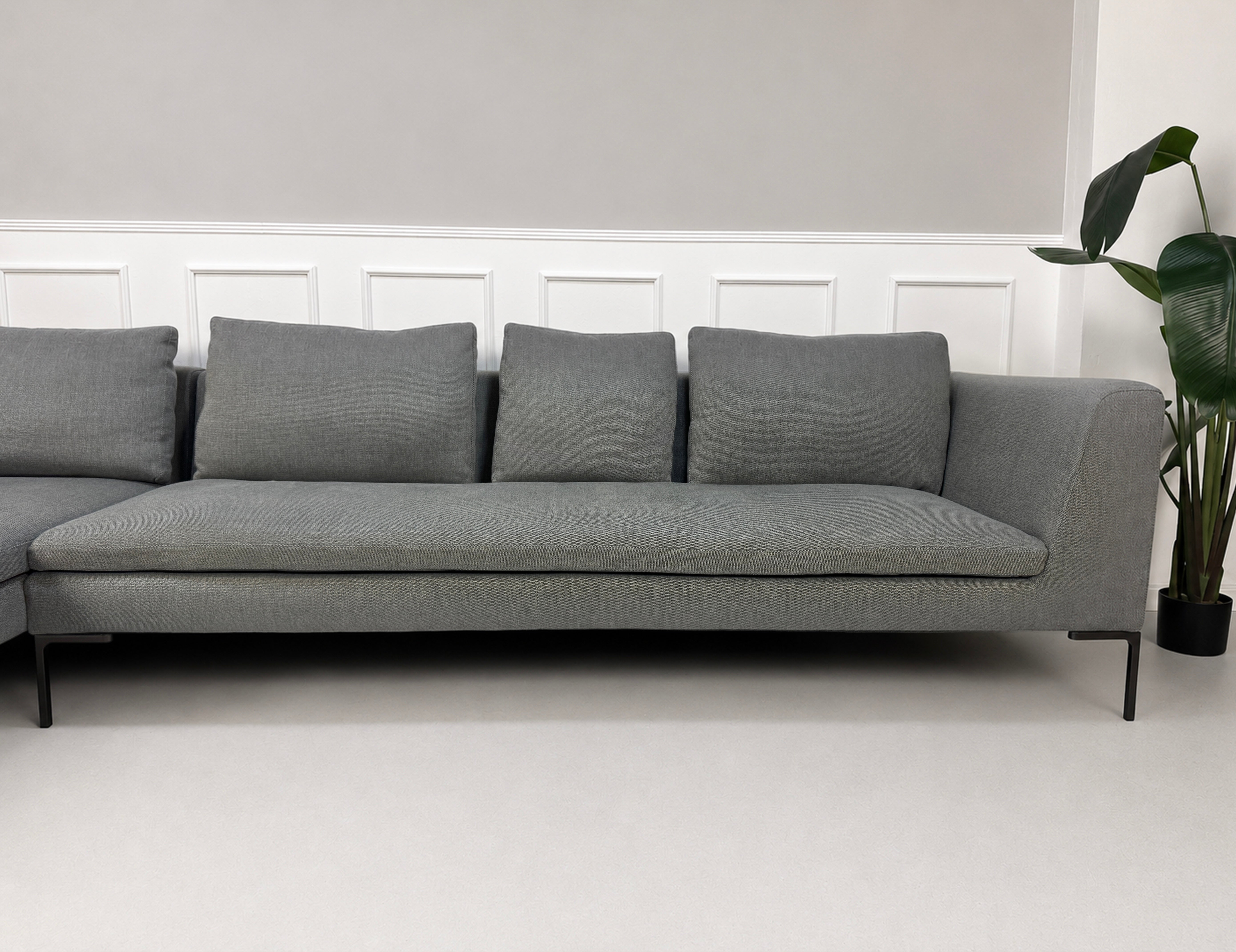 Gebrauchtes graues B&B Italia Charles Designer Stoff Sofa vor einer Wand, stilvoll und modern eingerichtet.