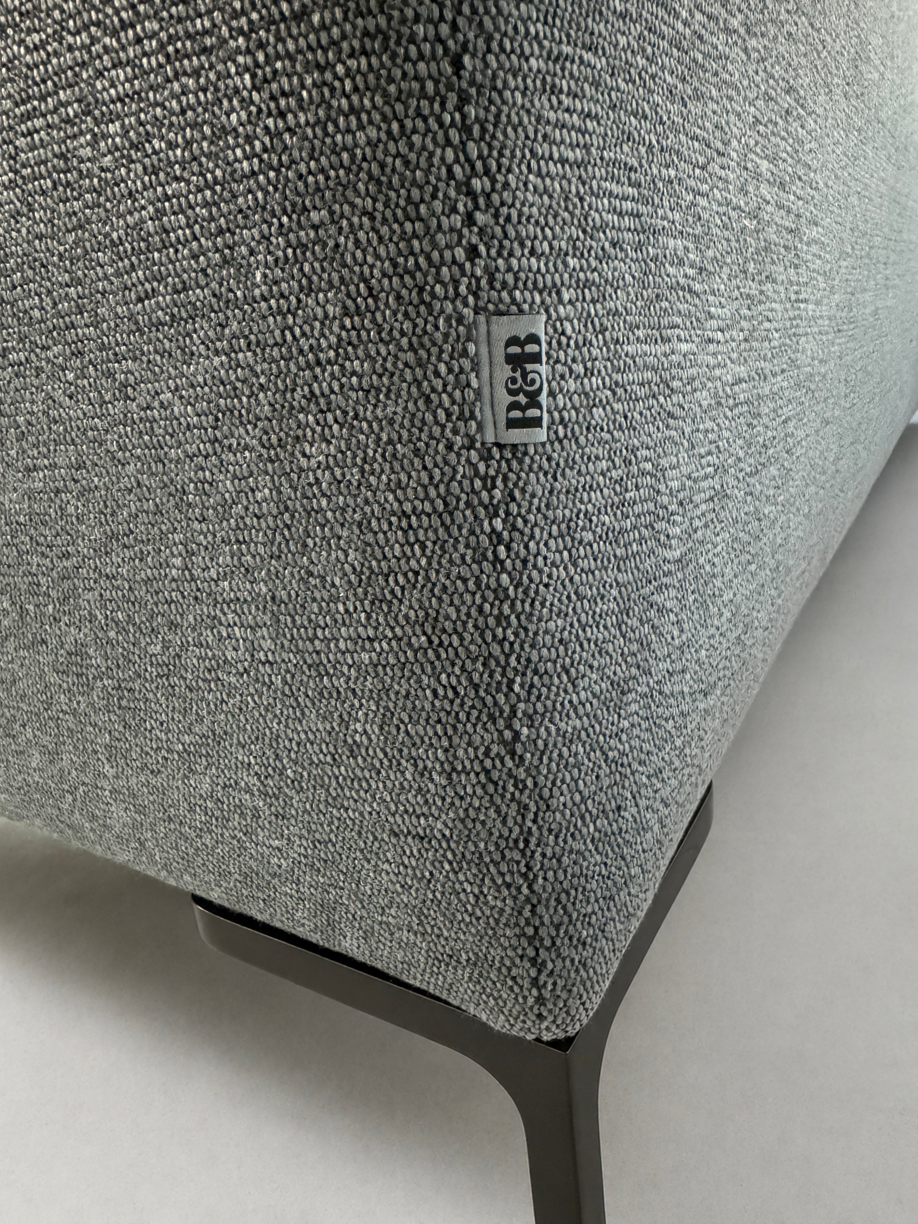 Gebrauchtes graues B&B Italia Charles Designer Stoff Sofa vor einer Wand, stilvoll und modern eingerichtet.