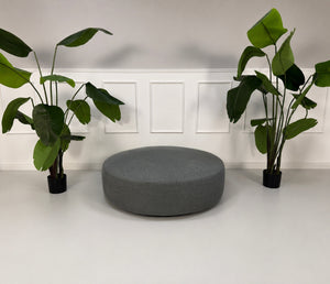 Gebrauchter grauer B&B Italia Charles Designer Stoff Hocker vor einer Wand, stilvoll und modern eingerichtet.