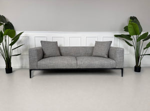 Gebrauchtes graues Walter Knoll Jaan Living Designer Stoff Sofa vor einer Wand, stilvoll und modern eingerichtet.