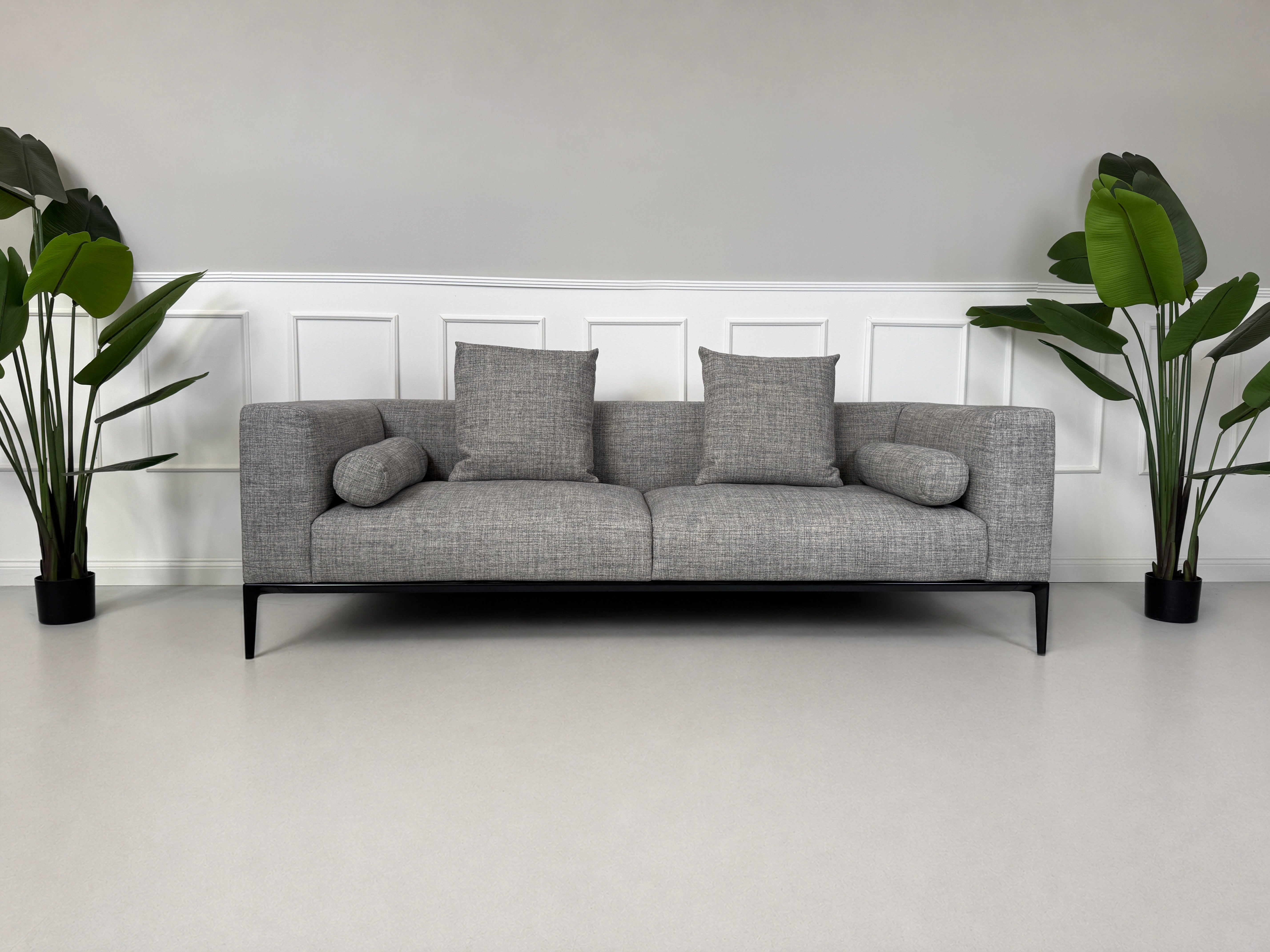 Gebrauchtes graues Walter Knoll Jaan Living Designer Stoff Sofa vor einer Wand, stilvoll und modern eingerichtet.