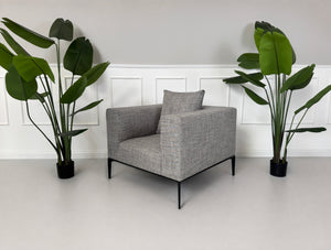 Gebrauchter grauer Walter Knoll Jaan Living Designer Stoff Sessel vor einer Wand, stilvoll und modern eingerichtet.