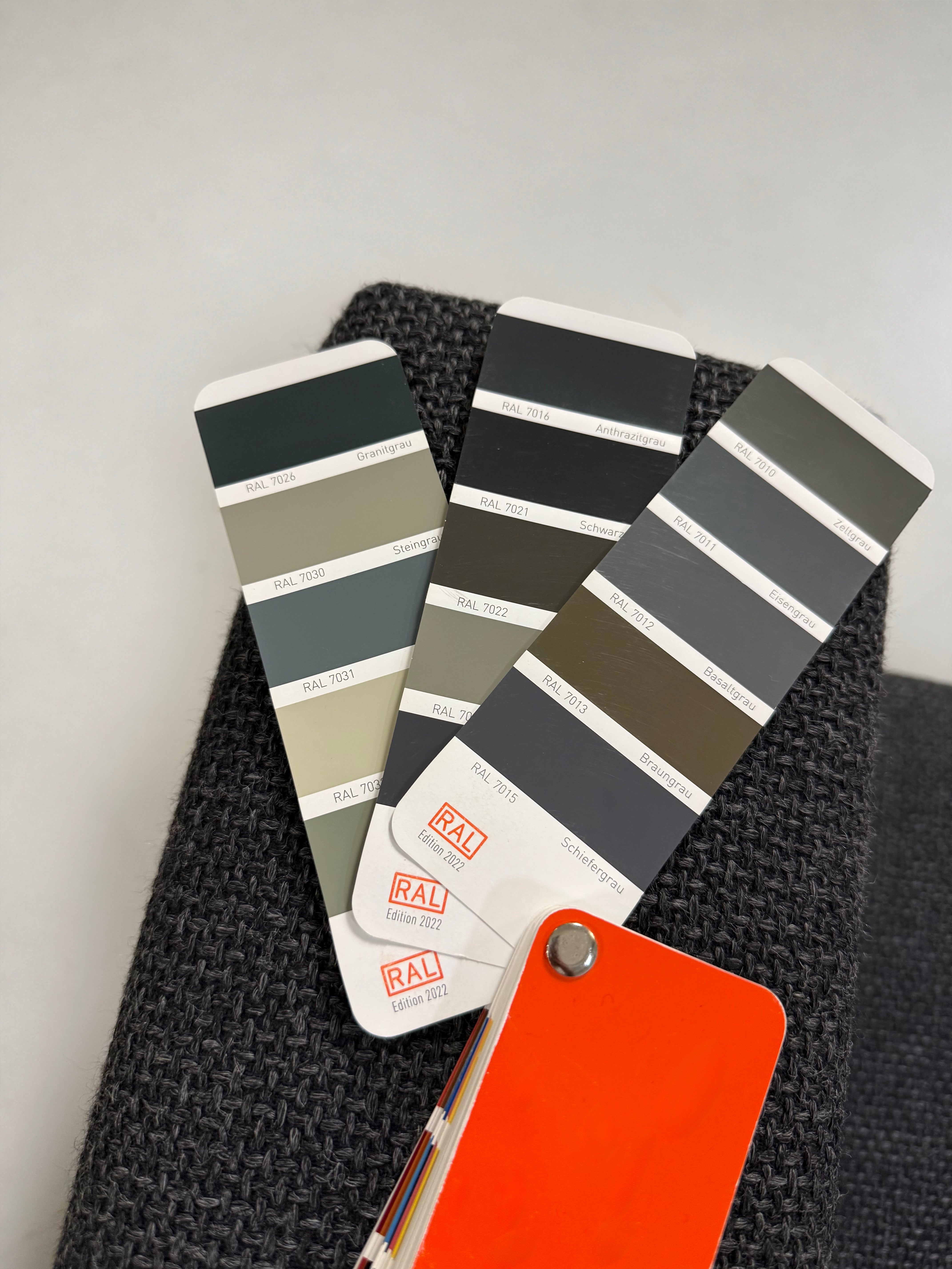 Gebrauchtes graues Brühl Moule Designer Stoff Sofa vor einer Wand, stilvoll und modern eingerichtet.