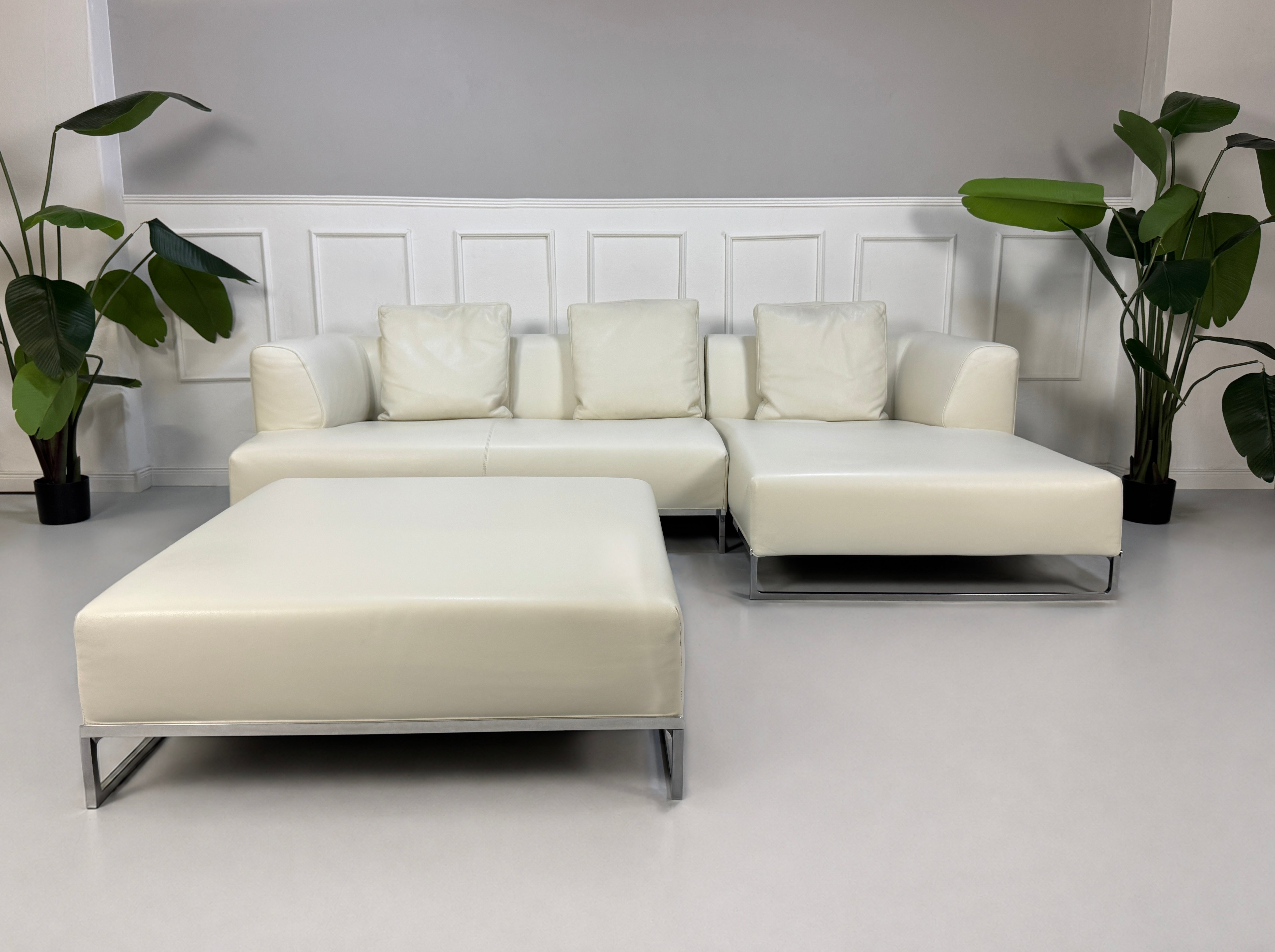 Gebrauchtes weißes B&B Italia Solo Designer Leder Sofa vor einer Wand, stilvoll und modern eingerichtet.