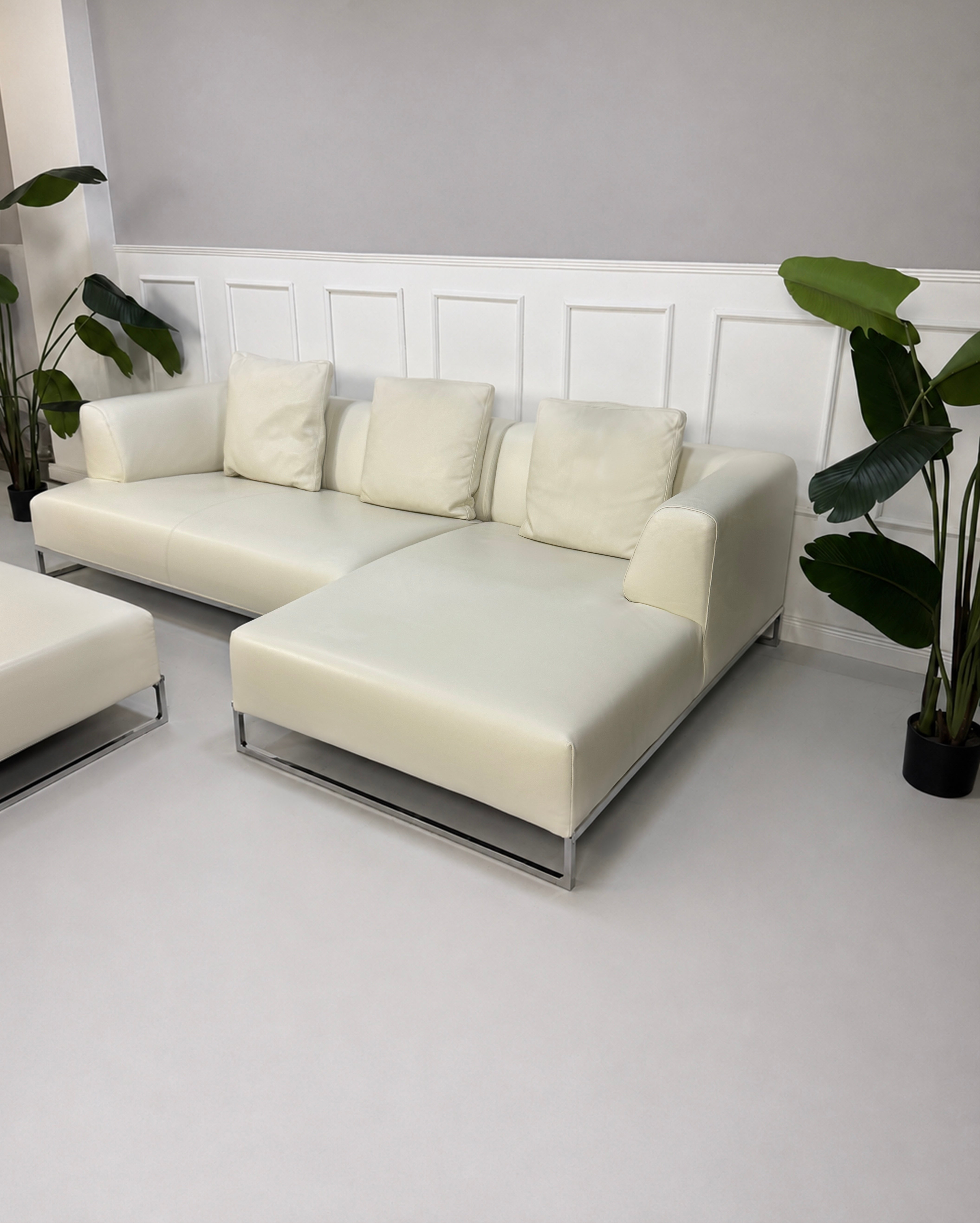 Gebrauchtes weißes B&B Italia Solo Designer Leder Sofa vor einer Wand, stilvoll und modern eingerichtet.