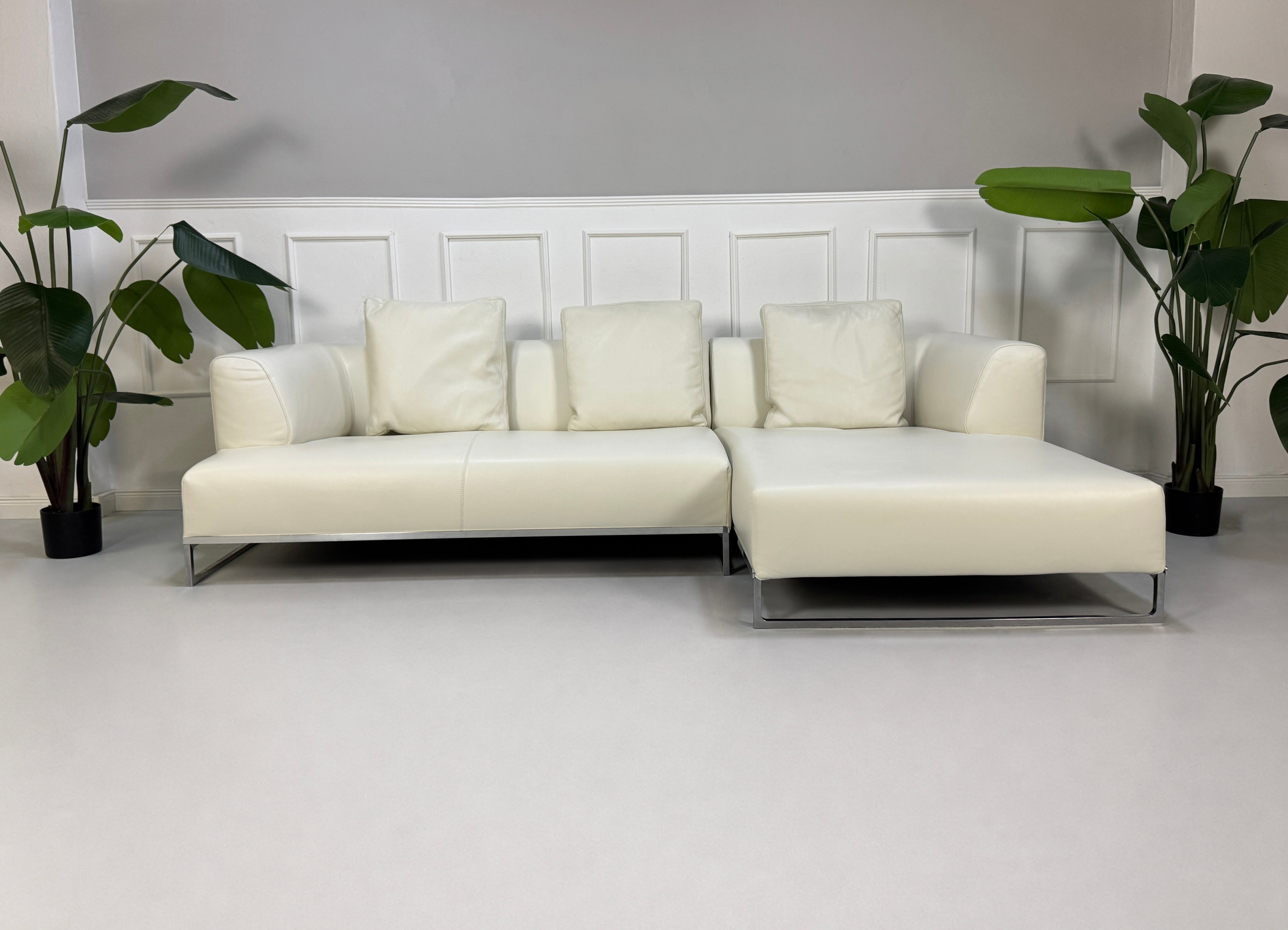 Gebrauchtes weißes B&B Italia Solo Designer Leder Sofa vor einer Wand, stilvoll und modern eingerichtet.